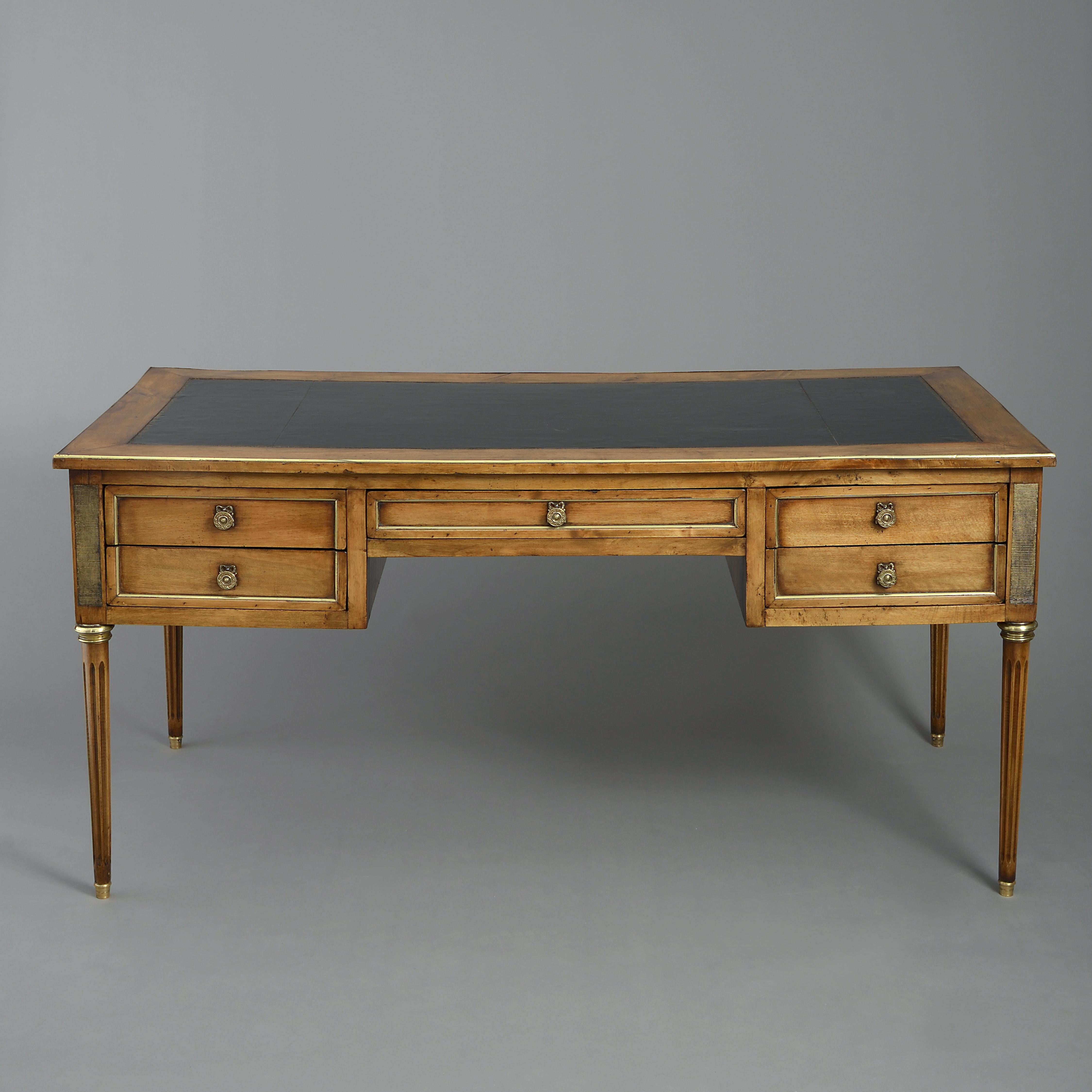 A late 19th century walnut and gilt metal mounted freestanding bureau plat, in the Louis XVI style, the gilt tooled leather writing surface having a pair of additional slides, over a long central drawer flanked by a pair of small drawers, all raised