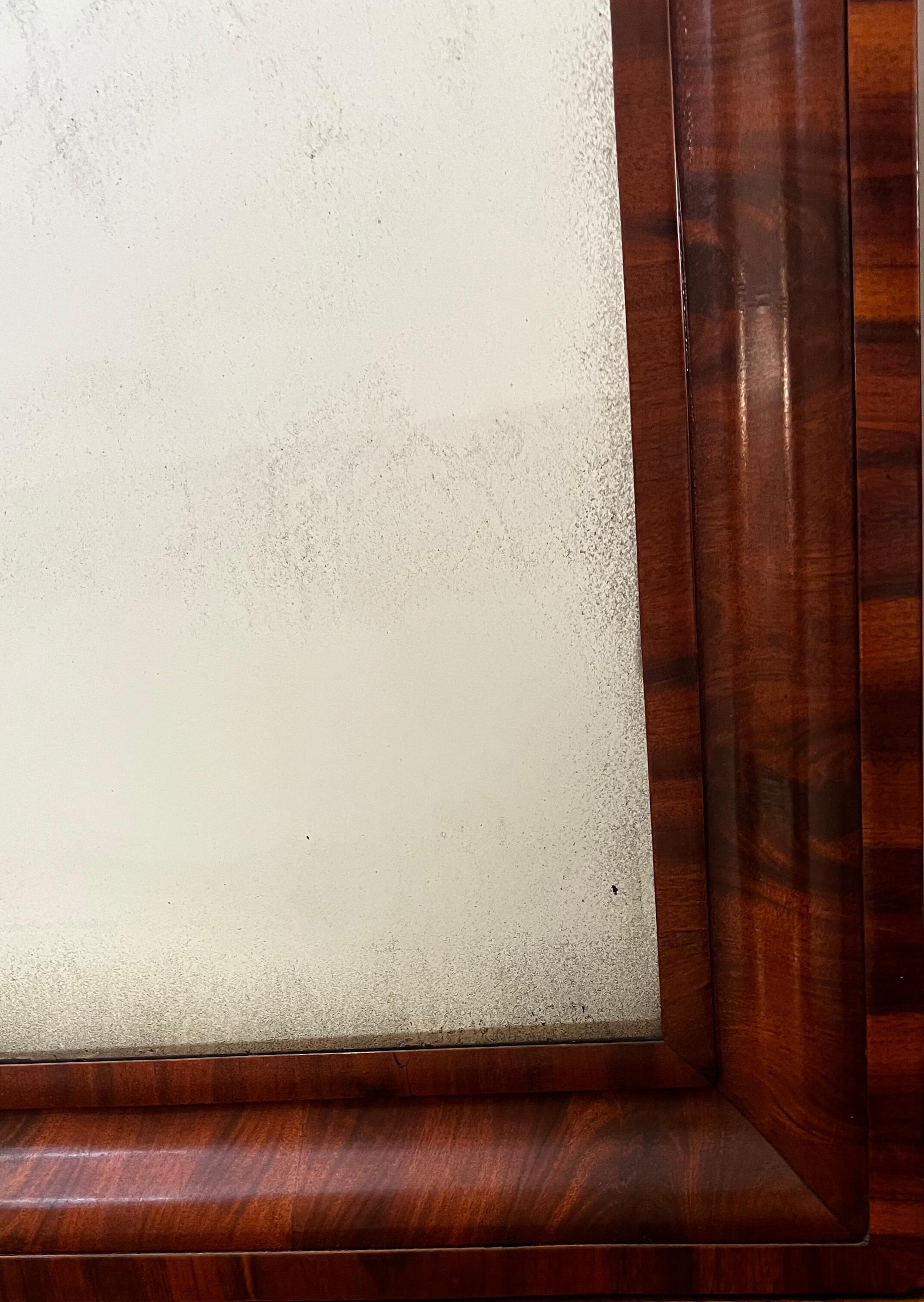 A stunning 19th-century mirror with a rich brown mahogany ogee frame. A classic piece that adds warmth and refinement to any wall.