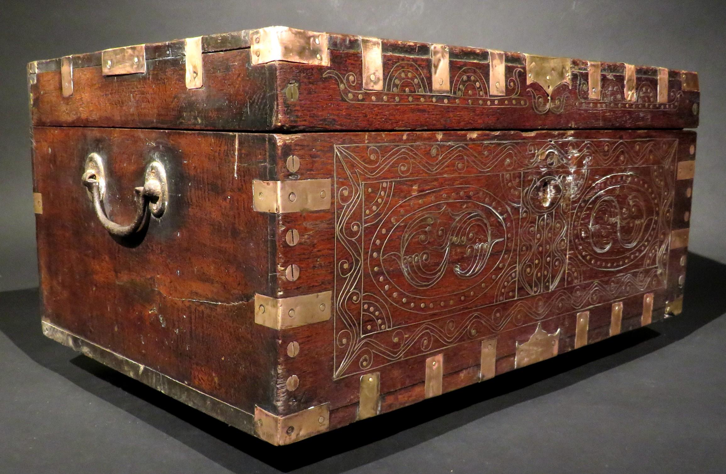 These boxes were made for British military officers who were posted in Burma (now Myanmar)  & India during the days of British rule. 
The brass & copper bound teak case is profusely inlaid with finely worked brass filigree wire and fitted with its