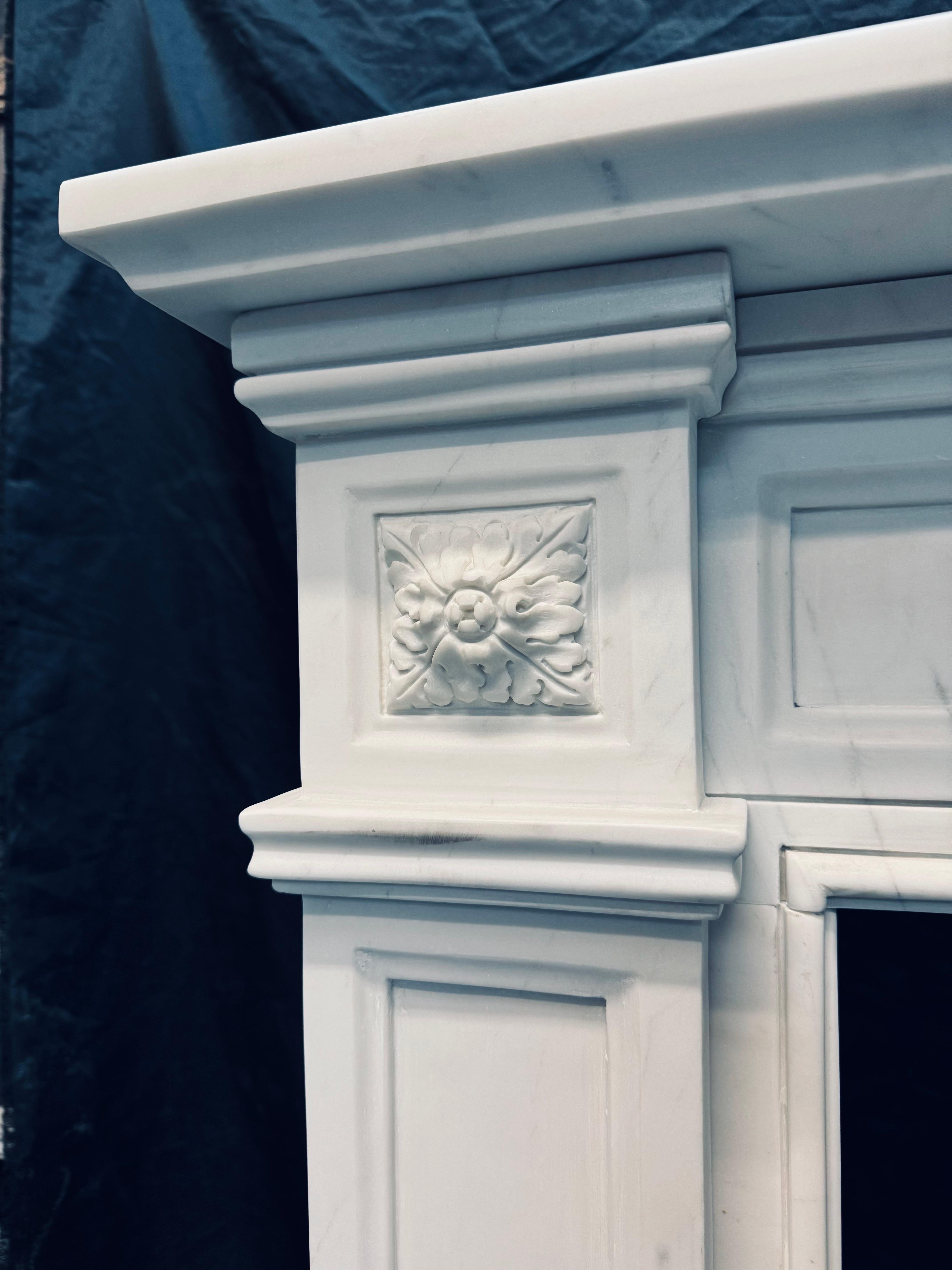 Cheminée bien équilibrée en marbre statuaire finement sculpté du XIXe siècle. Le plateau supérieur, substantiel et profond, est soutenu par une frise encadrée et évidée, elle-même flanquée de hauts montants avec des chapiteaux à rosettes carrées en