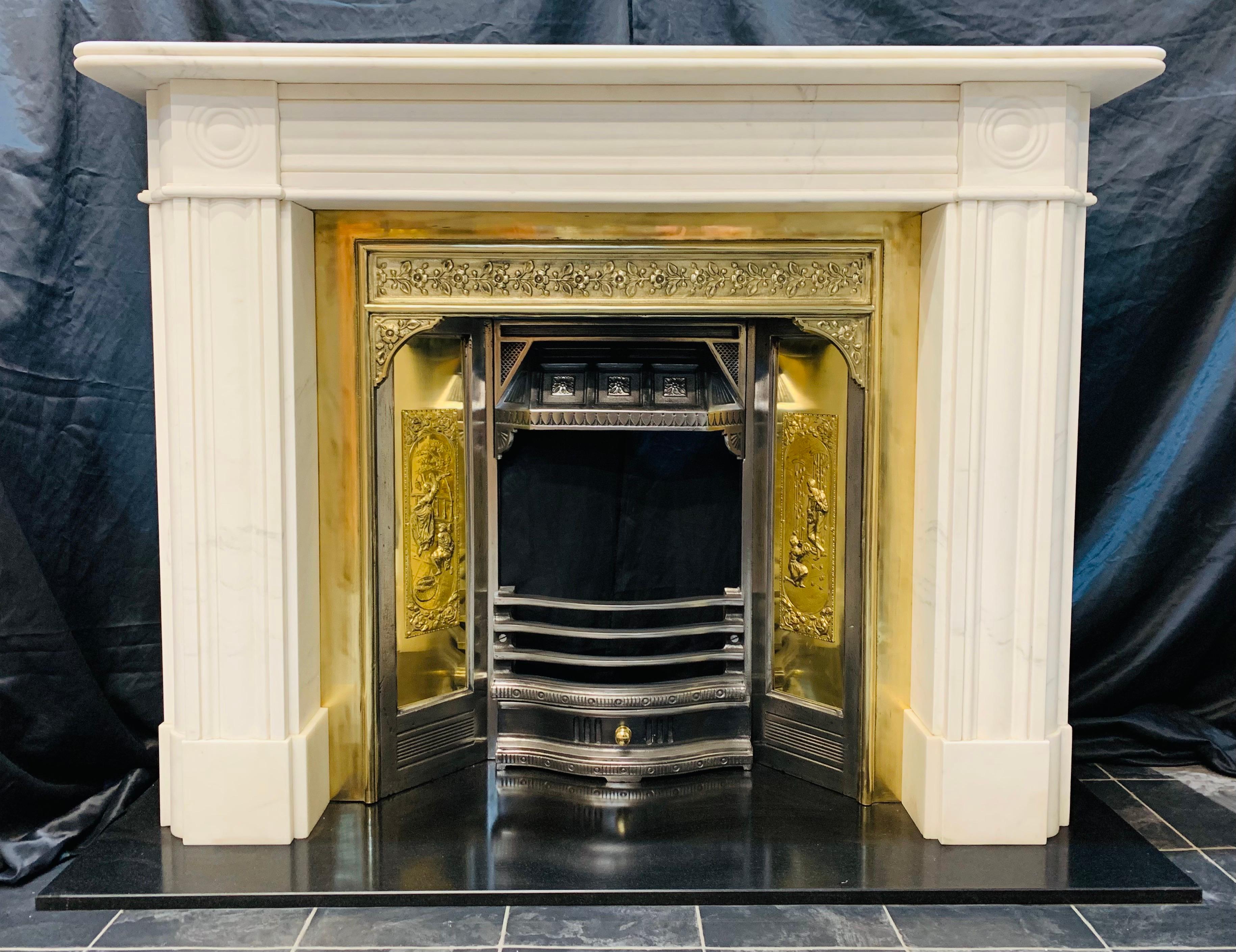 A very well proportioned 19th Century manner lightly veined Statuary marble bullseye fireplace surround. A reeded top self sits directly above a profiled frieze, flanked in turn by a pair of well carved bullseye rondel’s to each capital.