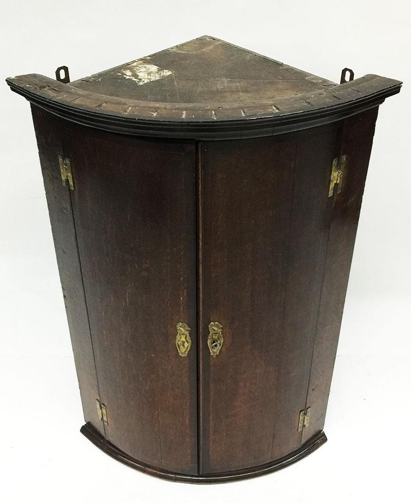 A 19th century oak hanging corner cupboard

A 19th century oak hanging corner cupboard with round doors and 3 shelves with copper fittings

The measurements are:
101 cm high and 67 cm wide
The depth is 47 cm.
The weight is 15 kilos.