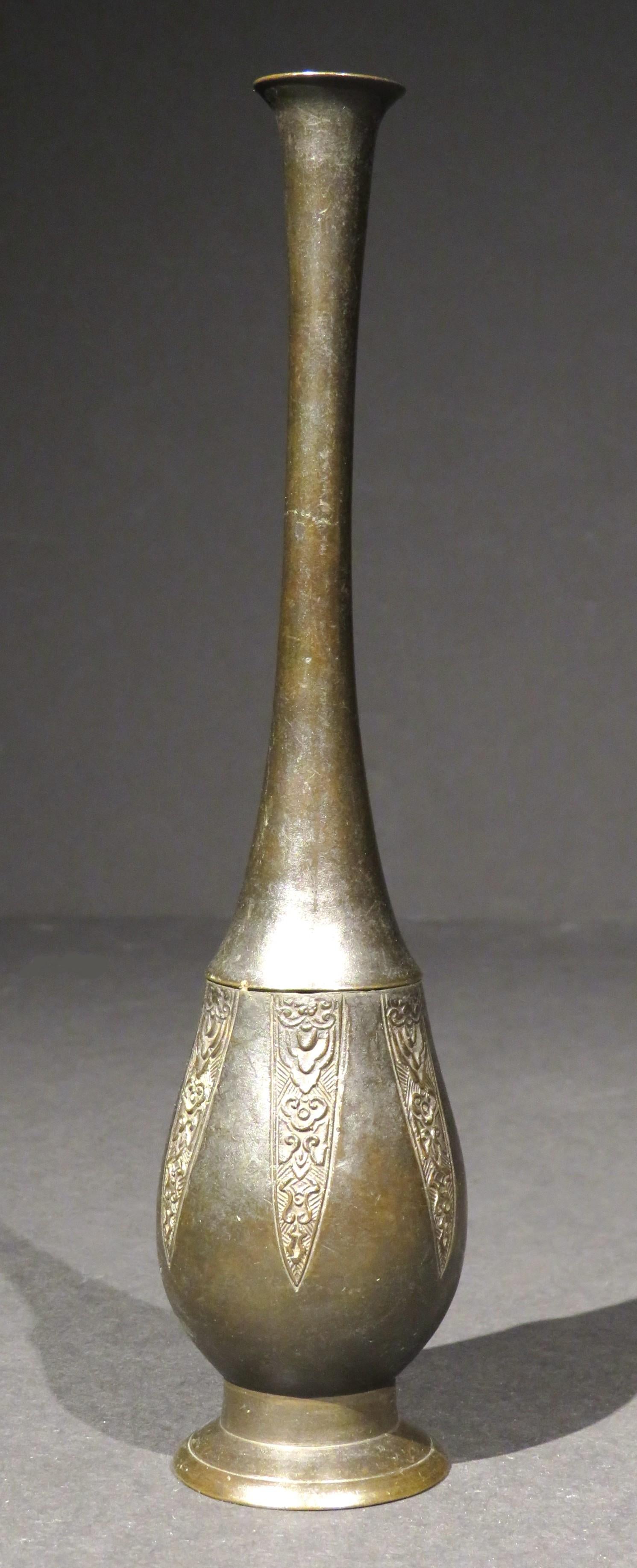The bottle shaped body decorated with foliate & geometric motifs within petal shaped panels, rising to a slender tapering neck to a flaring rim, raised overall upon a circular foot.