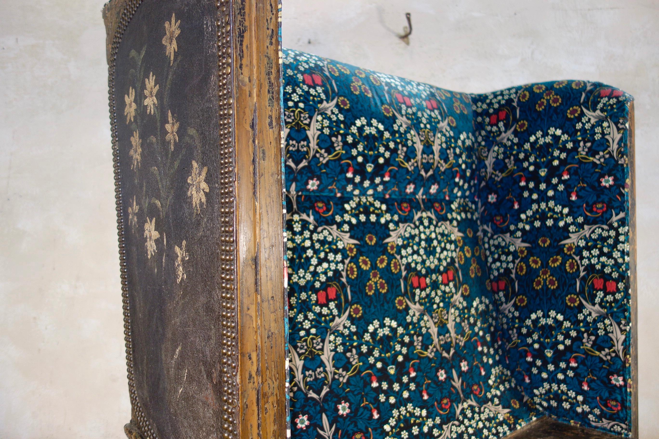 A unique 19th century Continental settle, featuring original folk hand painted leather inserts depicting large childlike floral motifs to each of the panels. This settle displays elaborately carved scroll feet with a lift up seat, the padded back