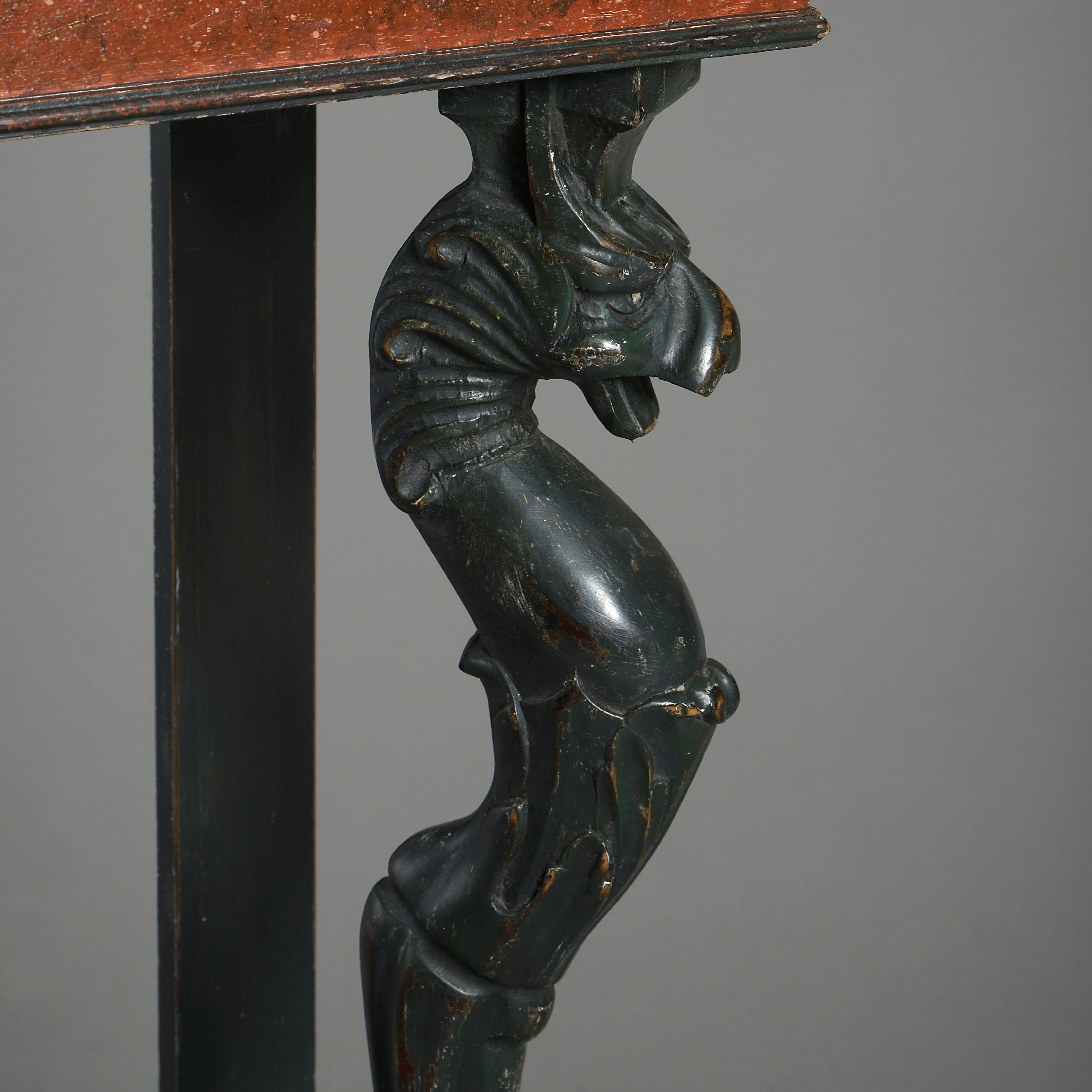 A mid-19th century painted console table in the neoclassical manner, the overhanging faux marble top above a simulated porphyry frieze, all set upon two carved ebonised griffin monopodia and having a serpentine faux porphyry lower shelf, raised on