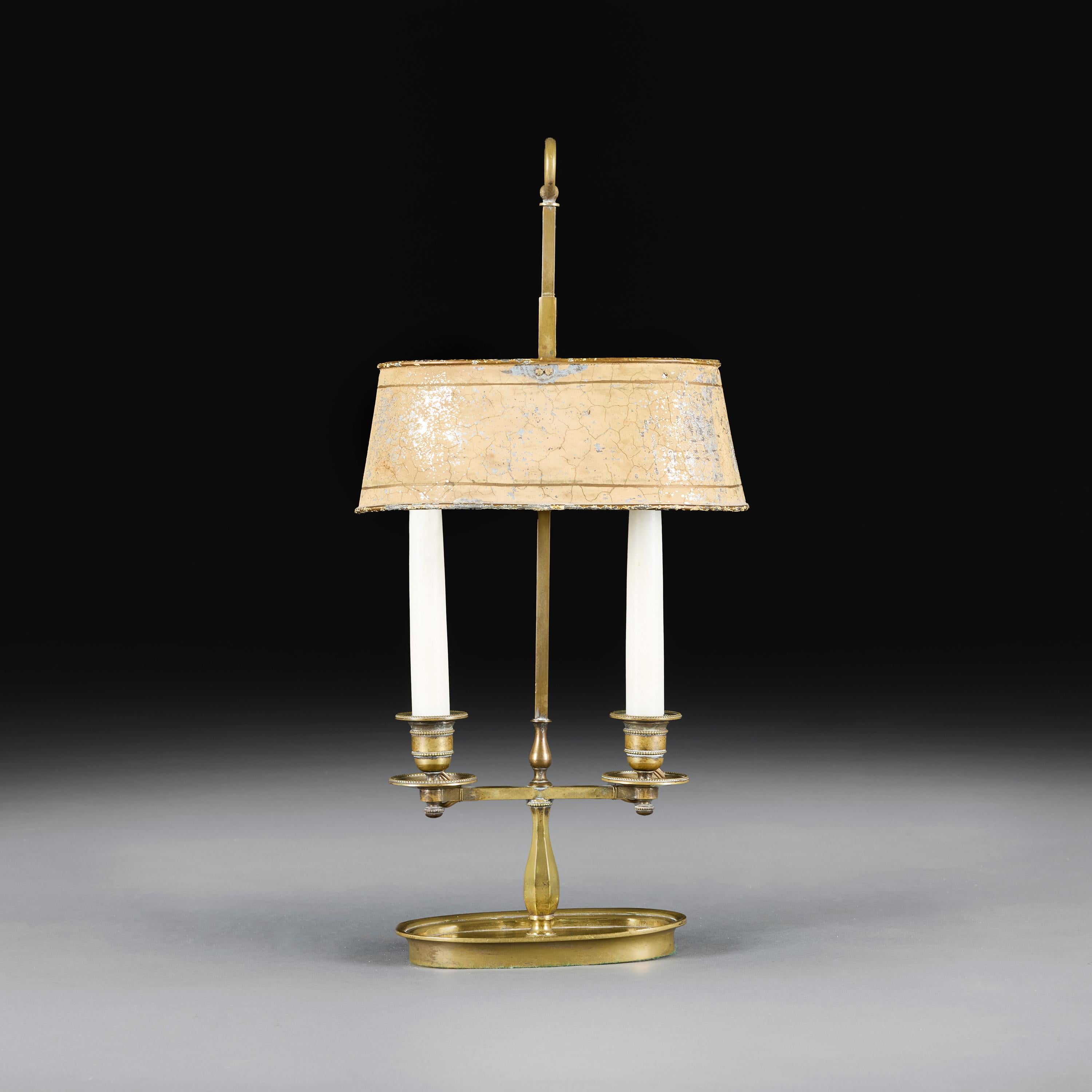 France, circa 1860

A mid-nineteenth century brass bouillotte lamp with twin candle holder and adjustable cream painted tole shade, surmounted by a brass hoop finial.

Height 51.00cm

Width 25.00cm

Depth 16.00cm