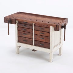 A 19th century painted work bench having two vice grips.