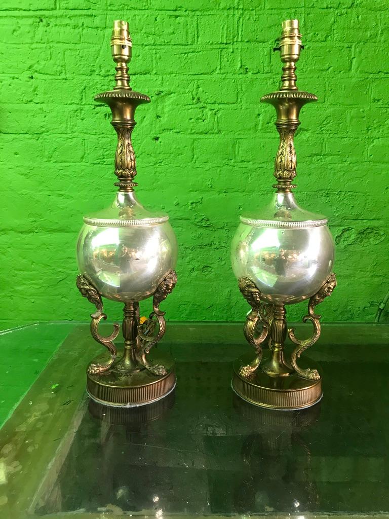 A 19th century pair of brass table lamps with heads and feathers with claw feet, on a circular brass stand. Lovely pair of lamps great teamed with pleated lampshade. Unusual and enjoyable to look at.