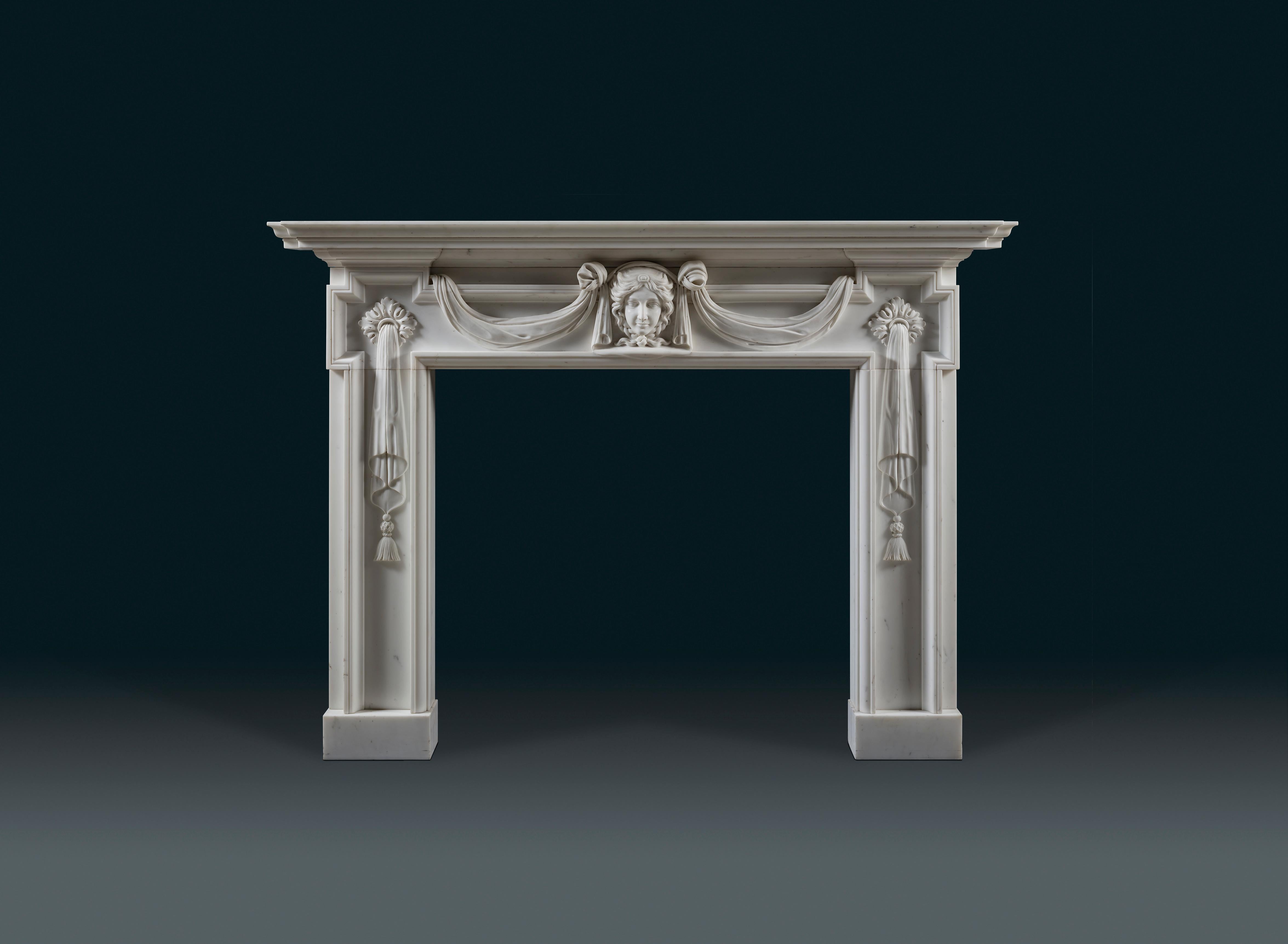 A 19th century Palladian revival Statuary marble chimneypiece. Venus, the Roman Goddess of love and wife to Vulcan (God of fire), presides over the fire from her central position in the frieze. Carved drapery frames her mask and runs behind the