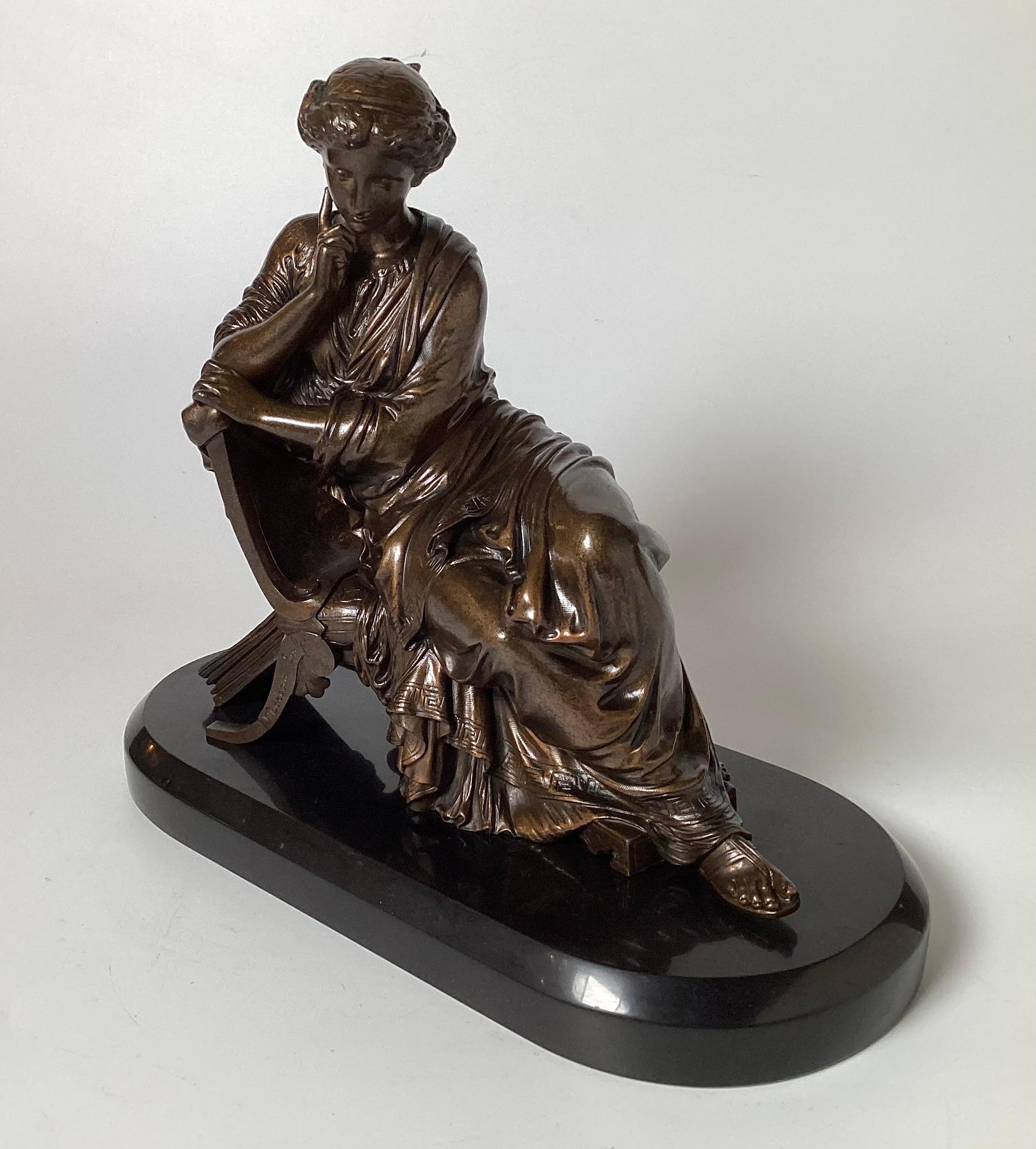 Bronze statue with dark colored patination featuring a seated classical lady after James Pradier (1790-1852). She is set on an oval polished slate marble base. This bronze is inspired by Sappho, a marble statue realized by Pradier in 1852, which is