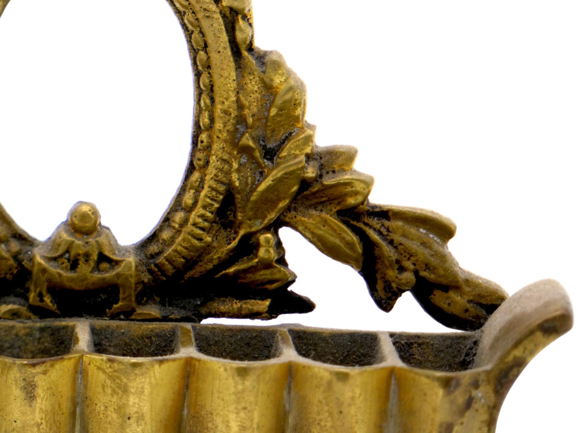 Lampada Hanukkah decorativa in ottone polacco del XIX secolo, realizzata in stile rococò.

Questa lampada di Hanukkah ha la forma di una sedia a sdraio con quattro gambe robuste e braccioli ai lati.

La piastra posteriore traforata ricorda un