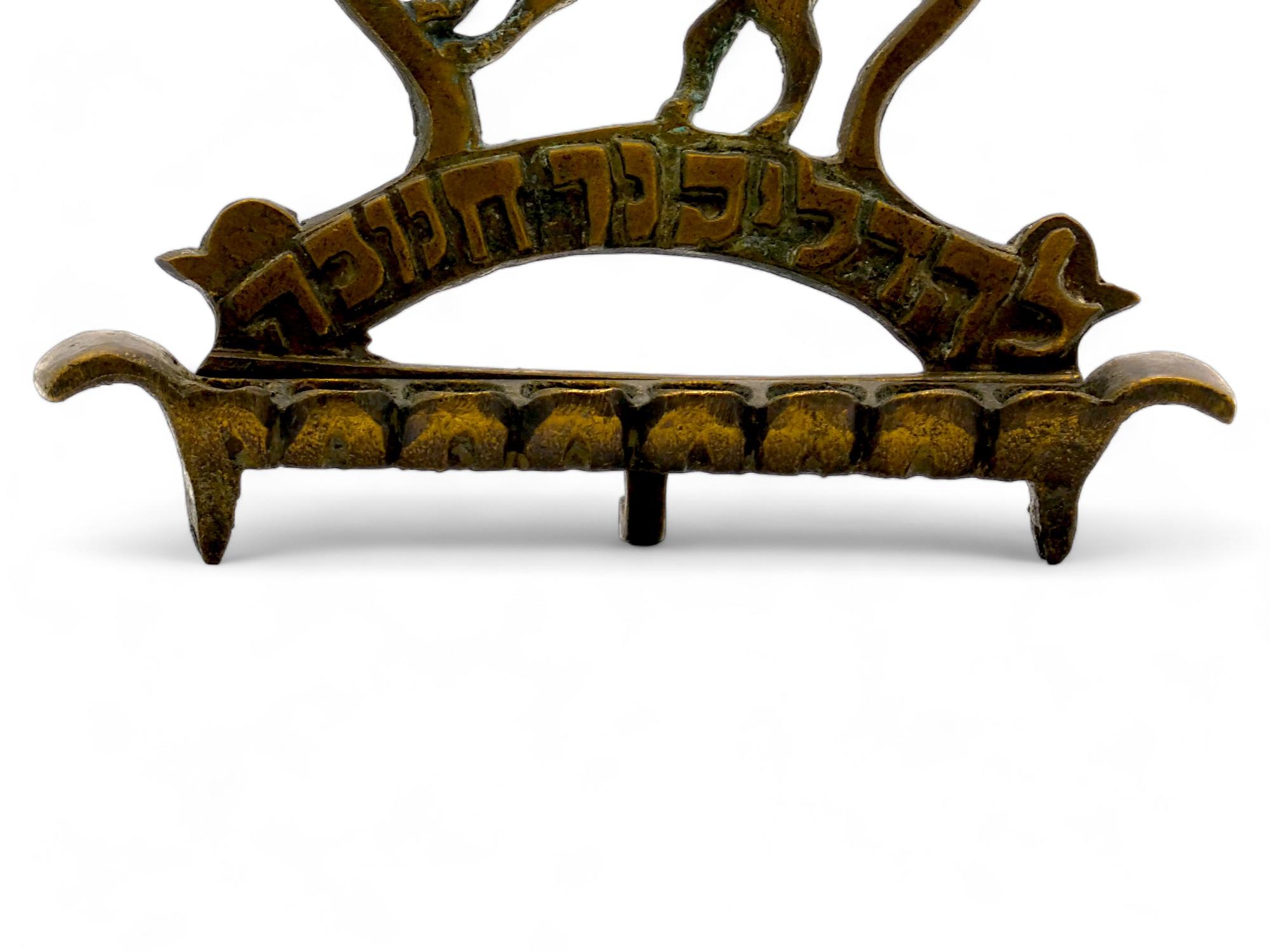 A 19th Century Polish Brass Hanukkah Lamp.

The cast backplate presents a pierced lion leaning on one side of an outlined majestic crown.

