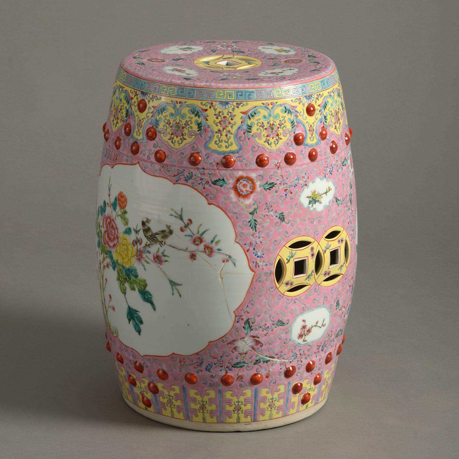 A late 19th century famille rose porcelain garden seat, in the form of a barrel, with cartouches of birds upon a pink ground.