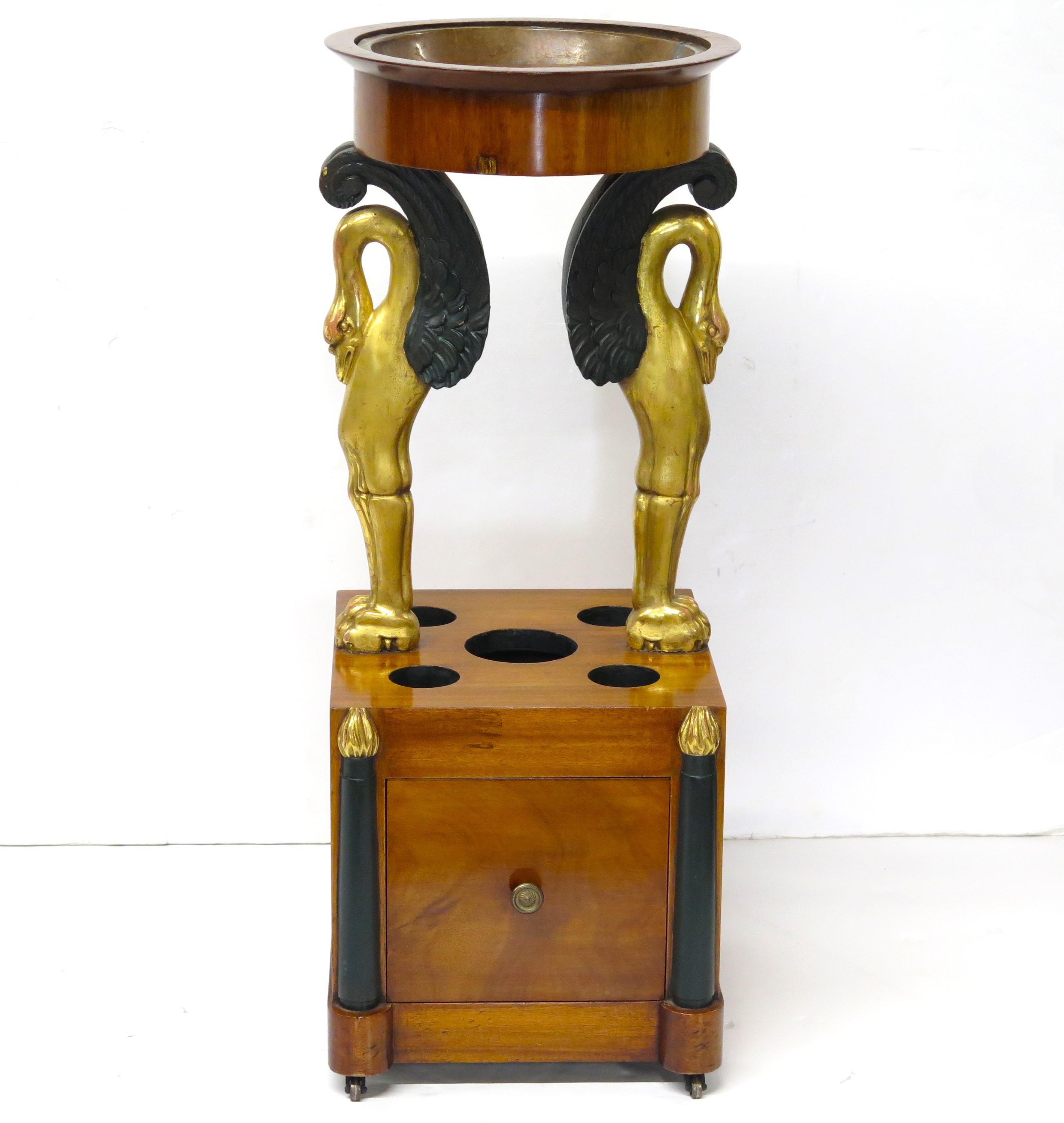 A 19th century rafraichissoir table with gilt and ebonized swan supports. Mahogany, circa 1845. France.