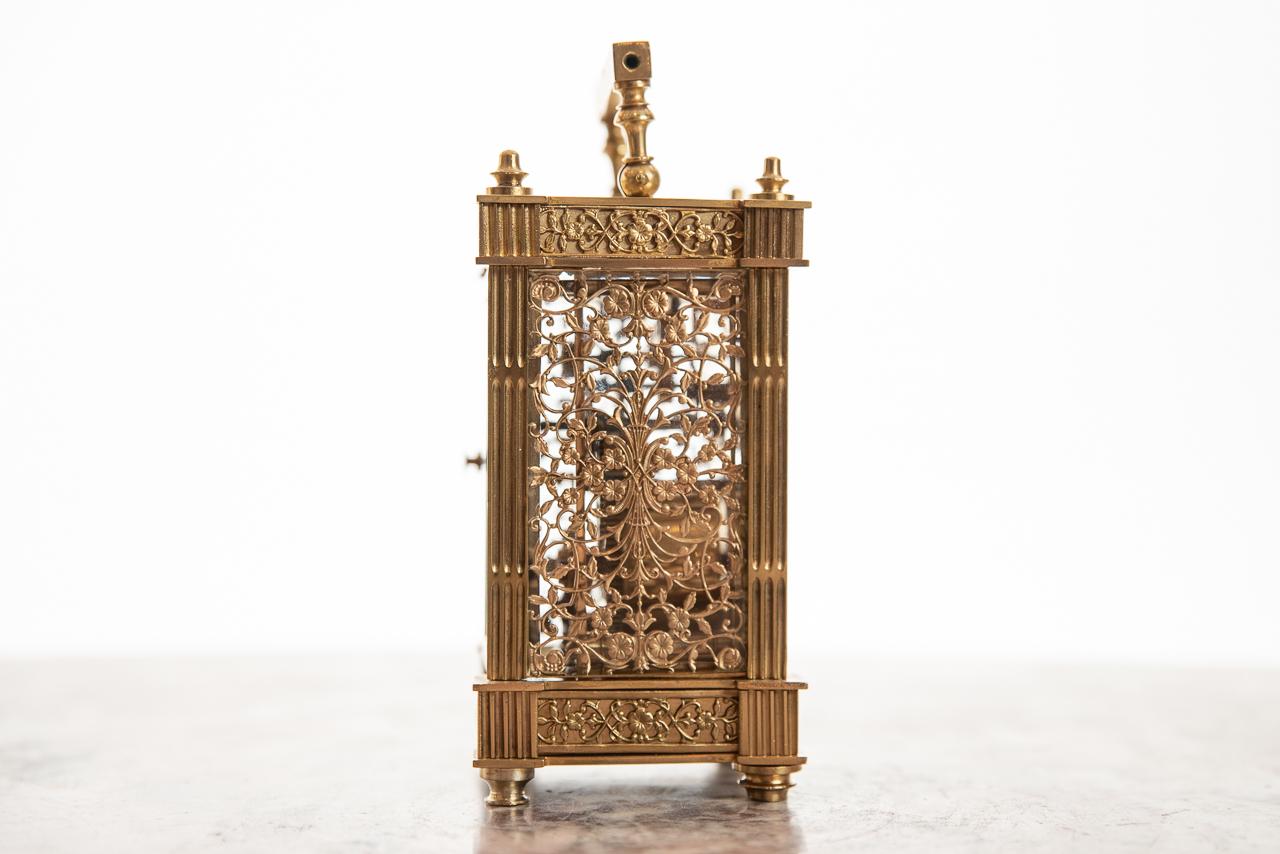 An outstanding and rare 8 day French brass cased carriage clock with a cream dial surrounded by a mask of filigree fretwork of flowers and foliage. This is also applied to the three other sides with fluted columns to all four sides of this rare