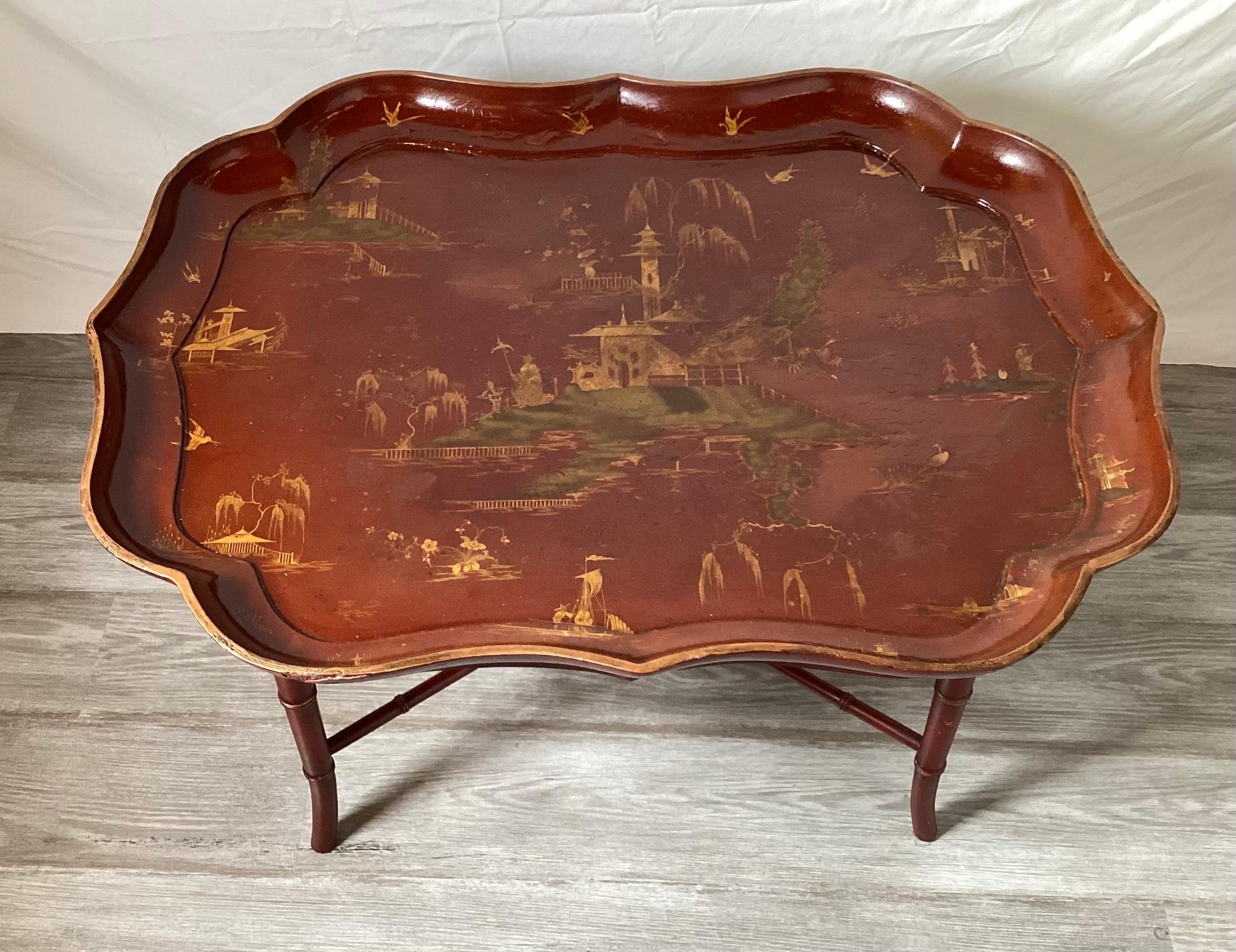A late 19th Century Chinoiserie tray top table.  The cinnabar red shapely tray with a later custom hand painted base.  The table from a Park Avenue Home decorated by Mario Buatta and used in a photo spread for Architectural Digest in the early