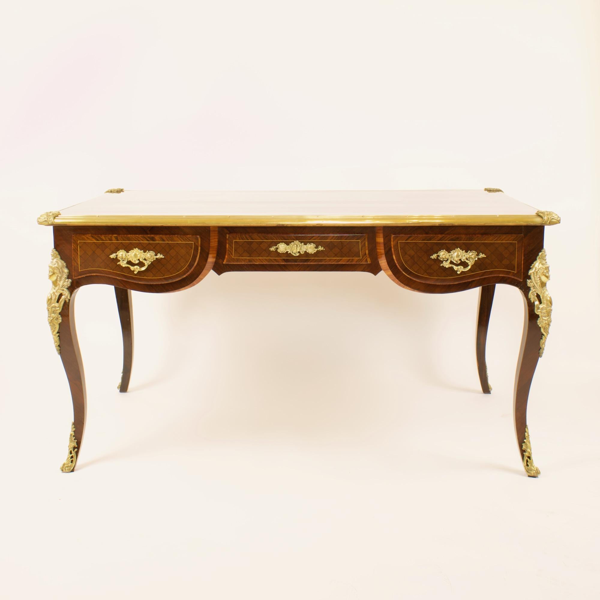 A 19th century Régence-/Louis XV-style gilt-bronze mounted and marquetry desk of freestanding form. With a brass banded rectangular top inset with a fine mirrored kingwood veneer surface, the brass banding with stylised floral corner cartouches.