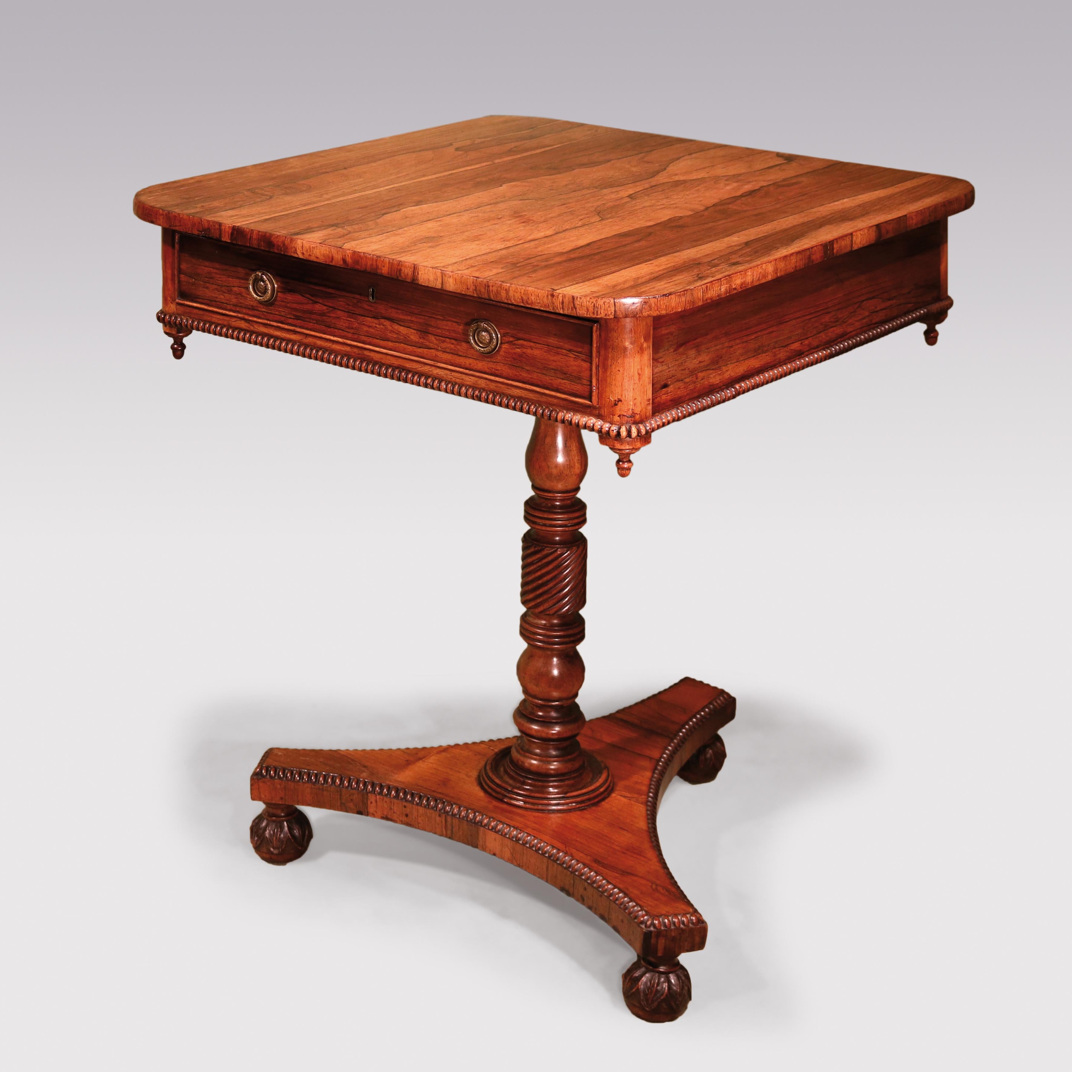 An attractive early 19th century Regency period figured and faded rosewood rectangular Occasional Table with drawer in frieze having beaded edge & drop pendants, raised on turned spiral twist stem ending on concave plinth with leaf carved ball feet.