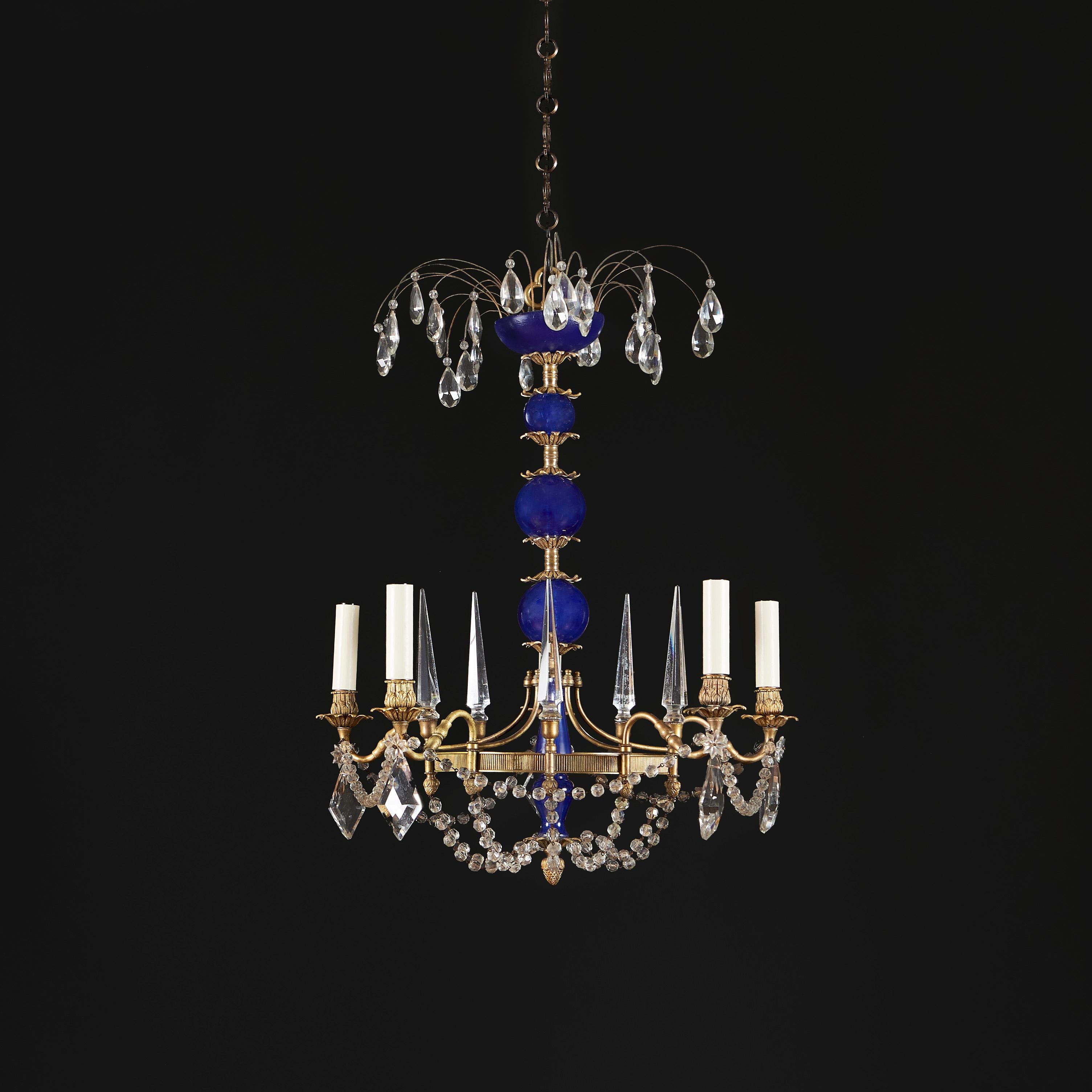 Russia, circa 1830

A fine early nineteenth century chandelier with five cylindrical blue glass beads, with tear drop mounts, with five arms with ormolu drip trays and five clear glass obelisks, the stem terminating at the base in a chased ormolu