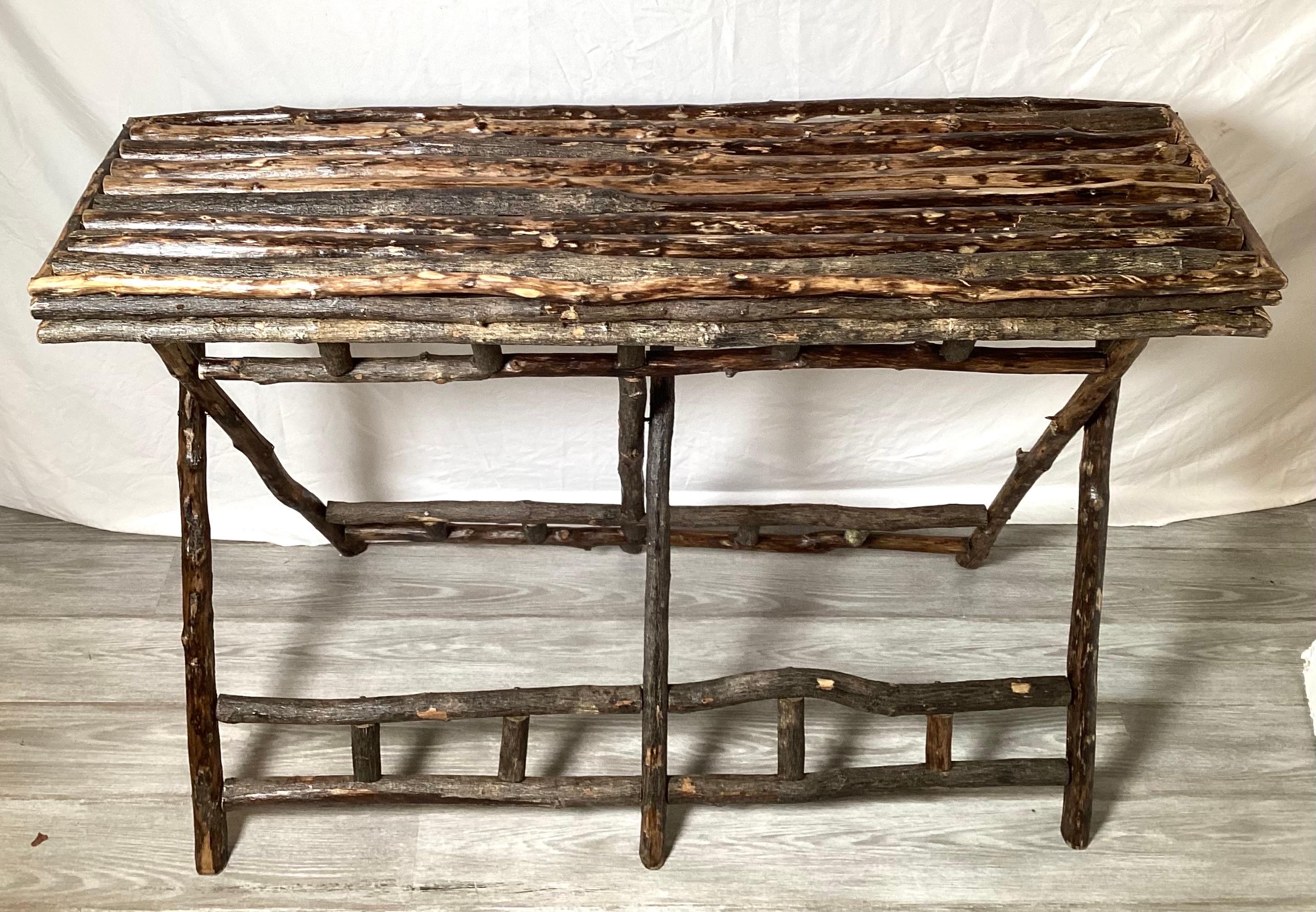 A 19th Century Hand Made tree limb folding Adirondack long rectangular table.  The top is removable with the bottom that folds up.  The natural bark with a sealed finish 48 inches long, 14.5 inches deep, great for a console table 