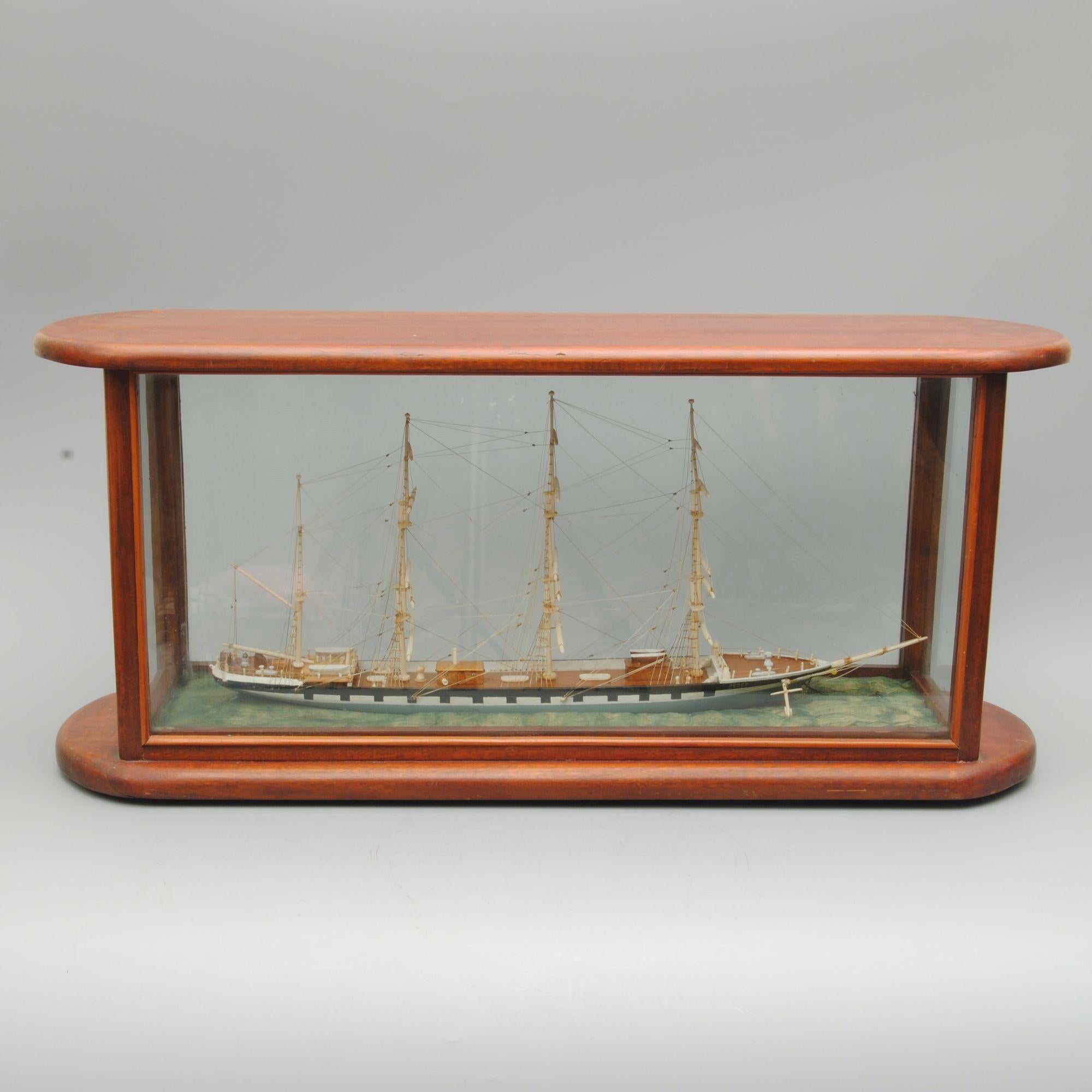 A decorative 19th century sailor made or scrimshaw model of Peggy, a four masted schooner presented in a glazed mahogany case.


 
