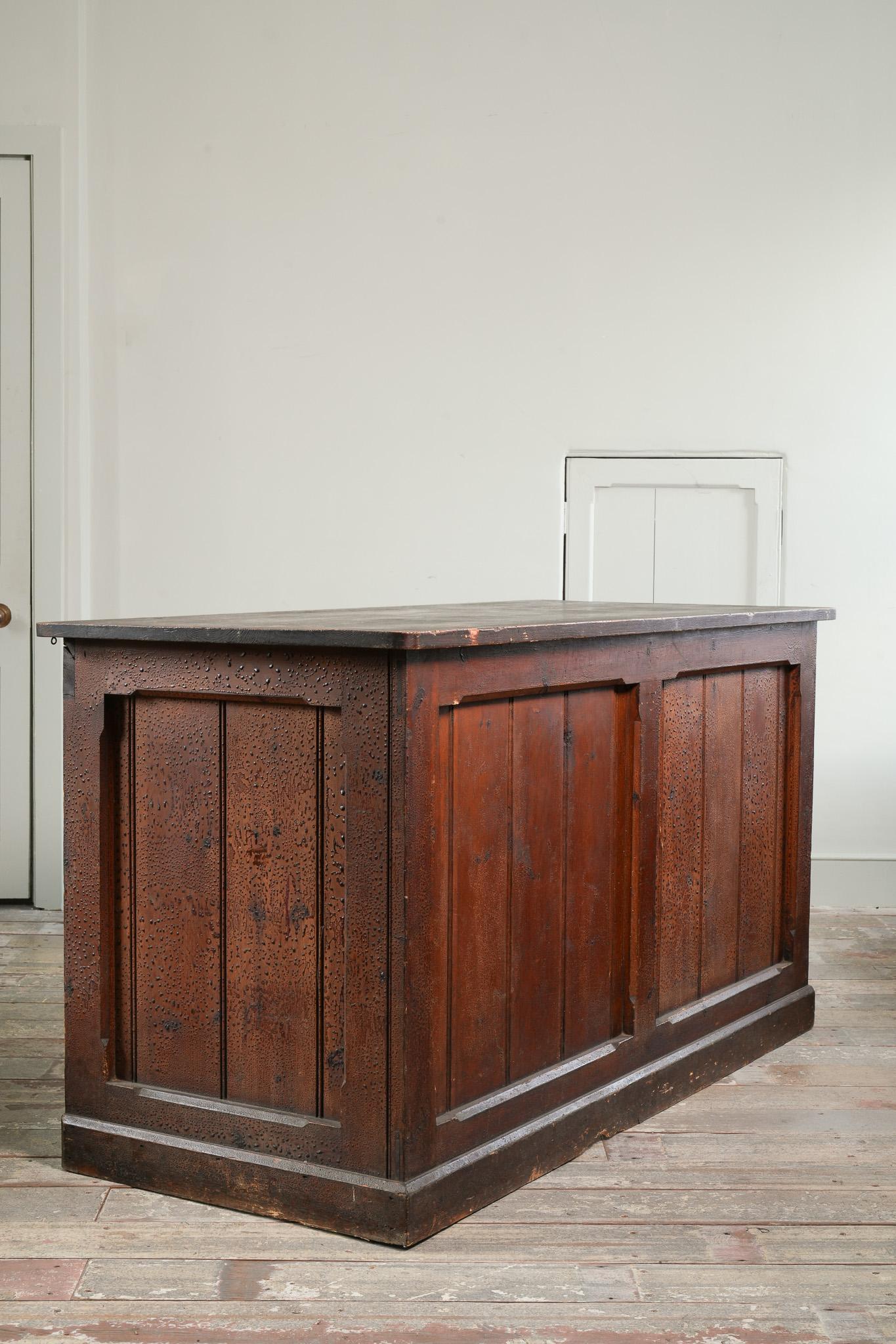 Comptoir de magasin en pitch-pin du XIXe siècle.

Décoration de surface originale bien patinée, étagère rudimentaire à l'intérieur.