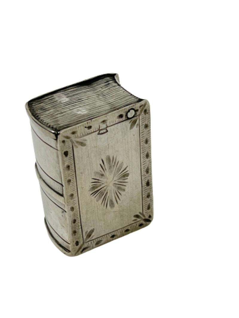 Scatola in argento a forma di libro del XIX secolo

Scatola d'argento a forma di libro con incisione. XIX secolo. 
Sotto la scatola c'è il marchio d'argento con la testa di cinghiale e nel coperchio il marchio fiscale e il segno del maestro con