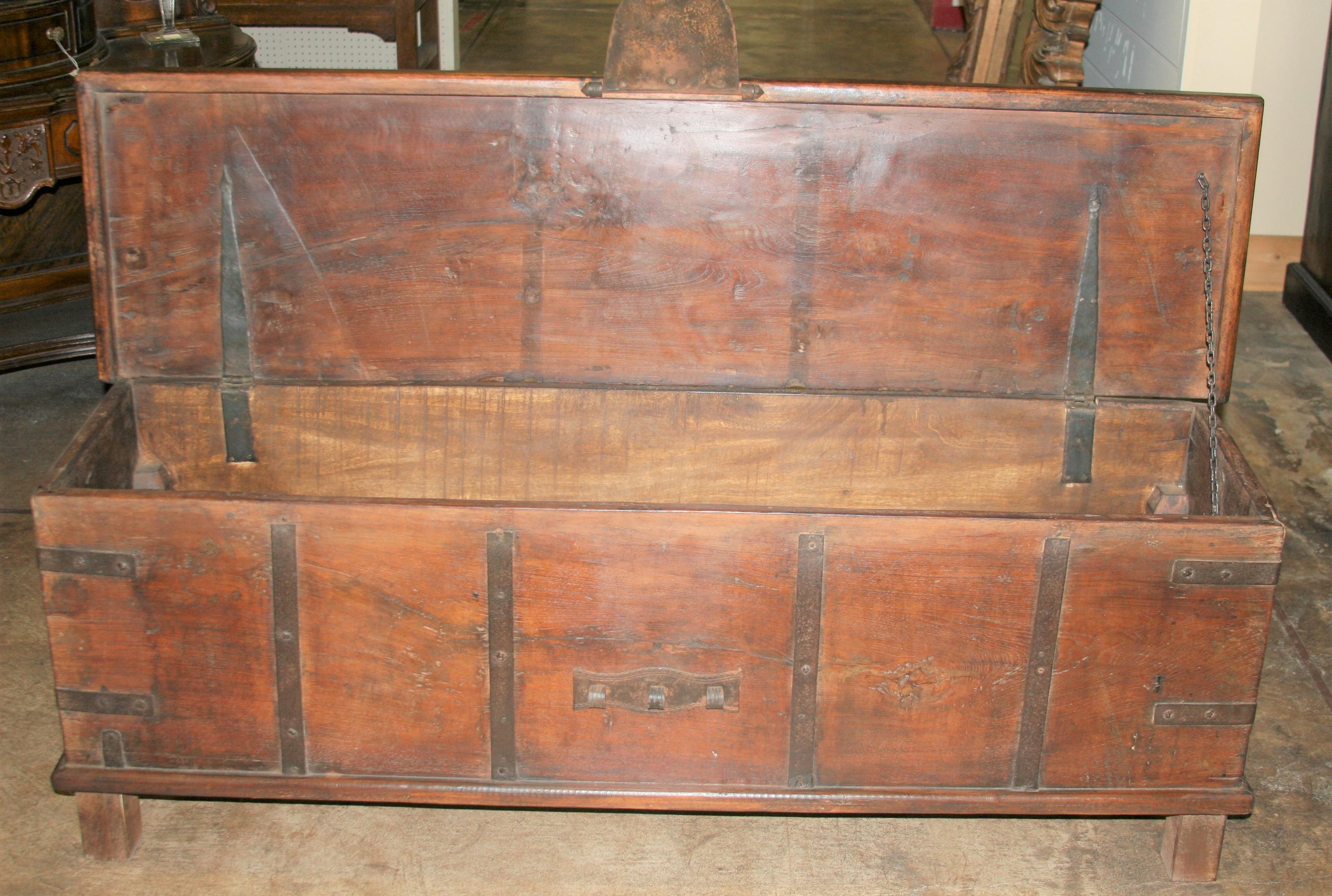 This chest was originally crafted as dowry chest in the 19th century but later modified as a storage cum bench for placing behind foot board of king size beds. This makes it a superb conversation piece for any grand bed room. The lid opens to a