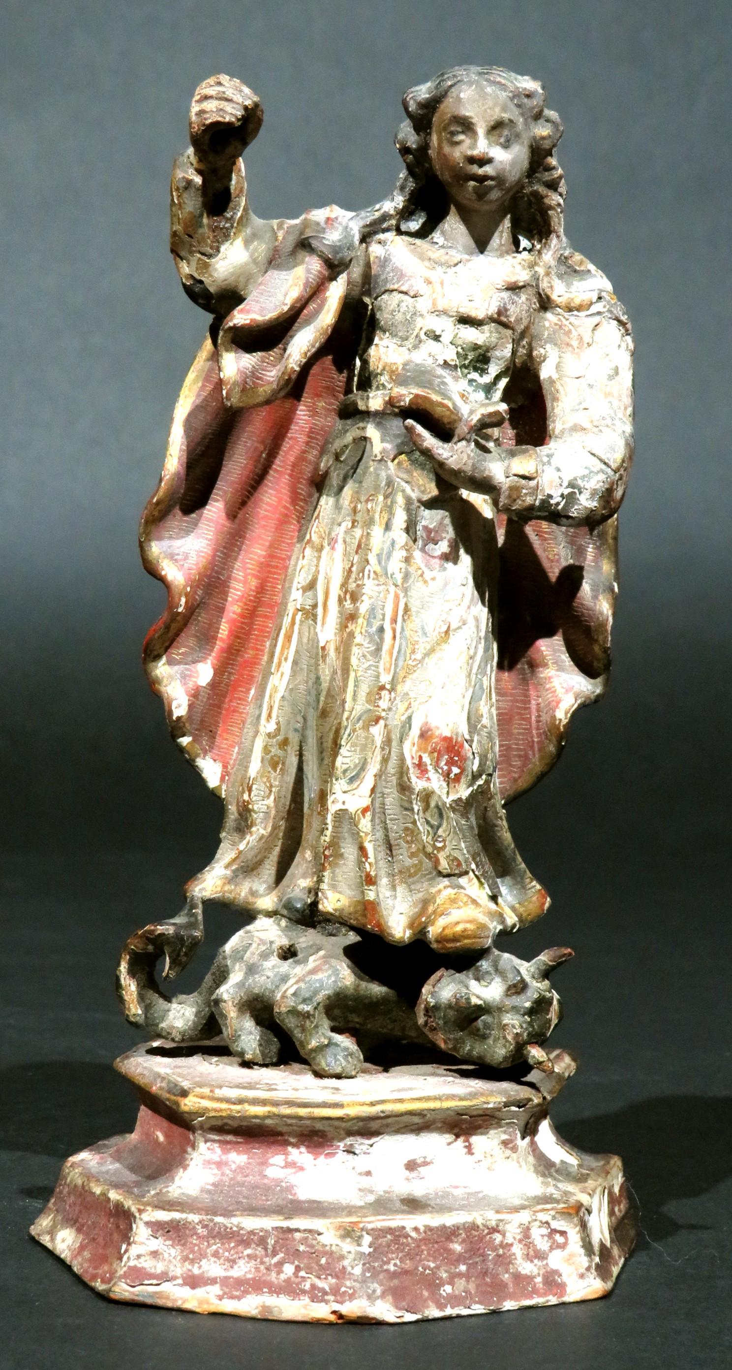 La figure naïve en bois sculpté à la main de la Sainte Mère vainquant la Bête apocalyptique, montrant la Sainte Vierge debout sur la Bête (Satan), la plaquant au sol avec son pied gauche sur son dos, tout en l'empalant avec une lance (absente), sa
