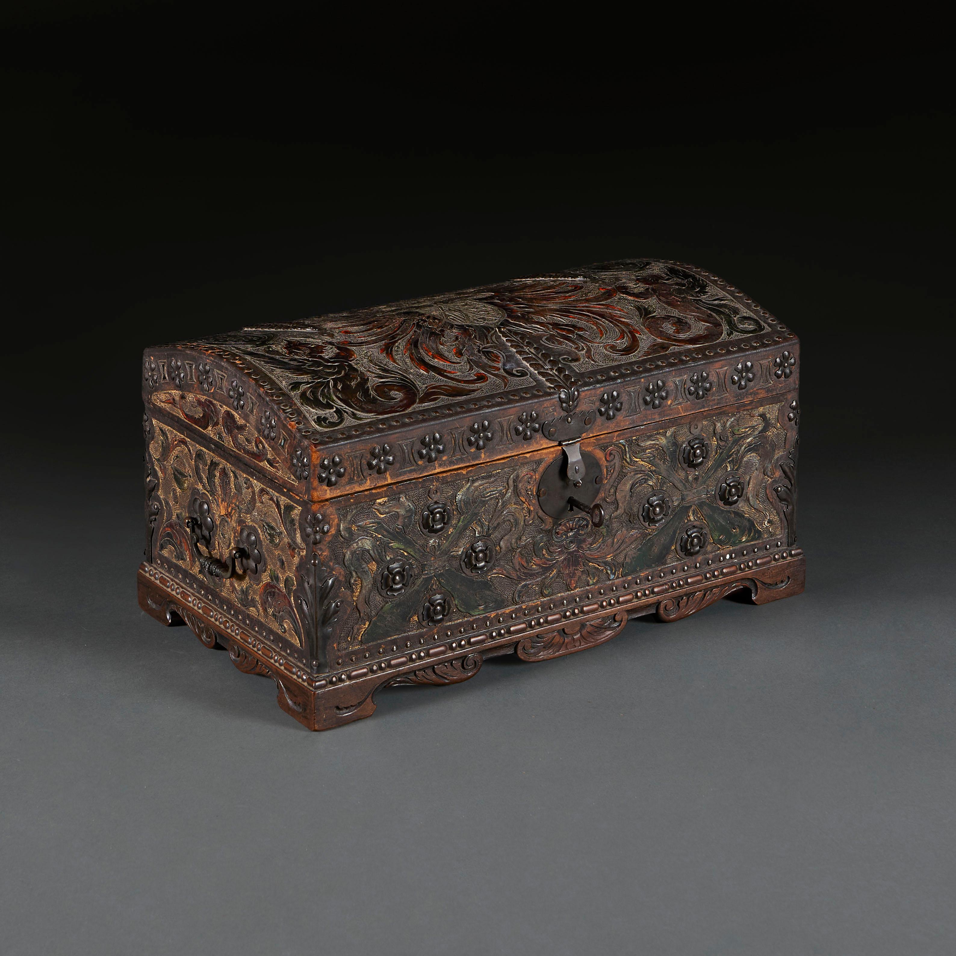 Spain, 1890

A late nineteenth century Spanish wood and leather casket with foliate tooling throughout, the domed top depicting the Greek figures Scylla and Charybdis, the borders lined with iron flowerhead studs and the sides with bail pull