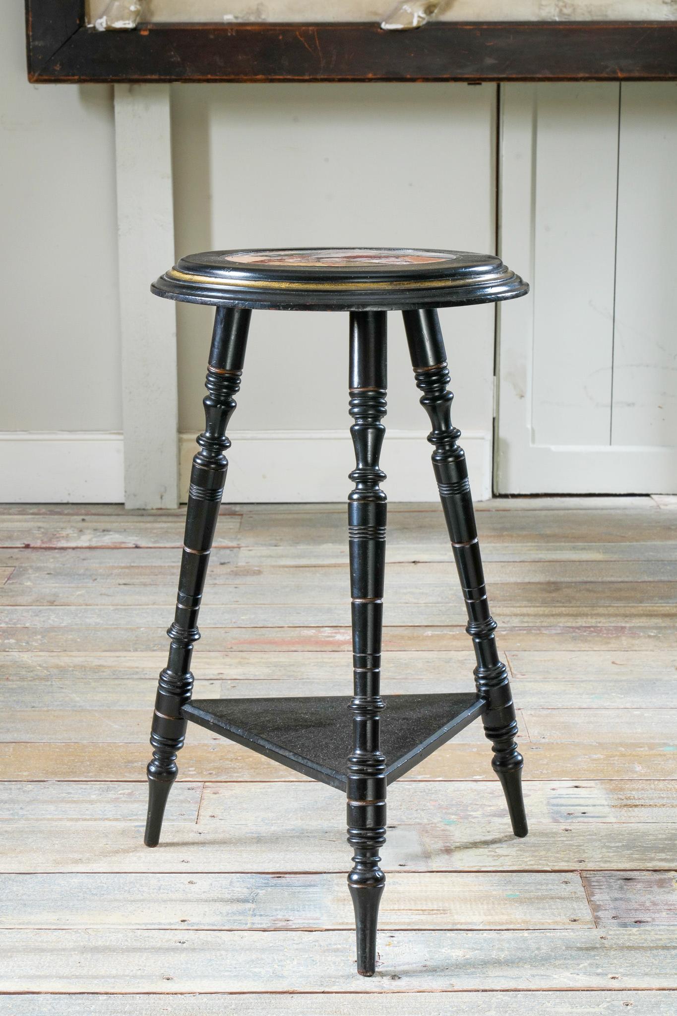An ebonised  and gilt centre table with an inset specimen marble top.