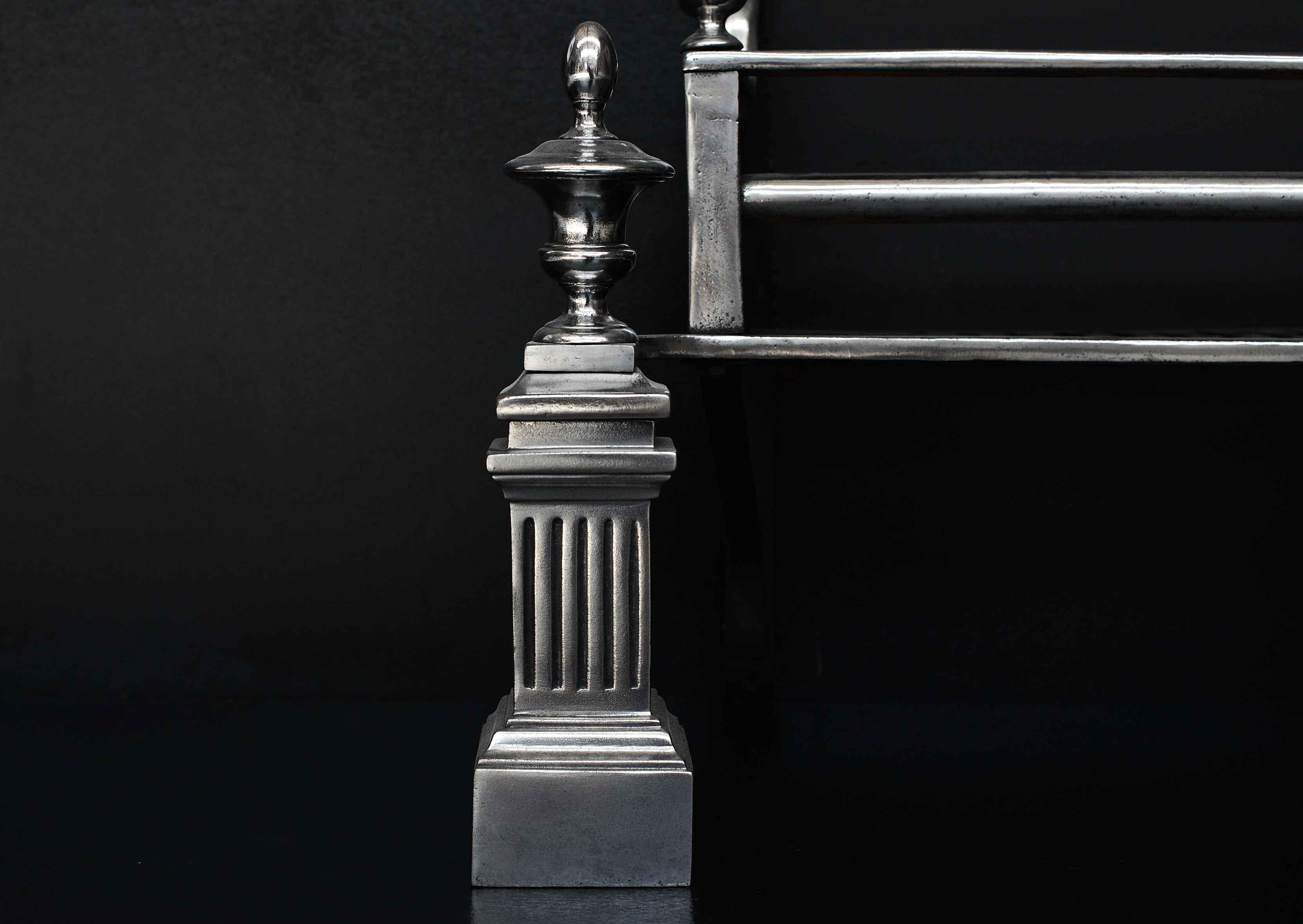 A 19th century steel firegrate. The square, fluted uprights surmounted by polished steel finials. The rectangular burning area with with straight front bar and shaped returning side cheeks to cast iron back.

Width At Front:	675 mm      	26 ⅝
