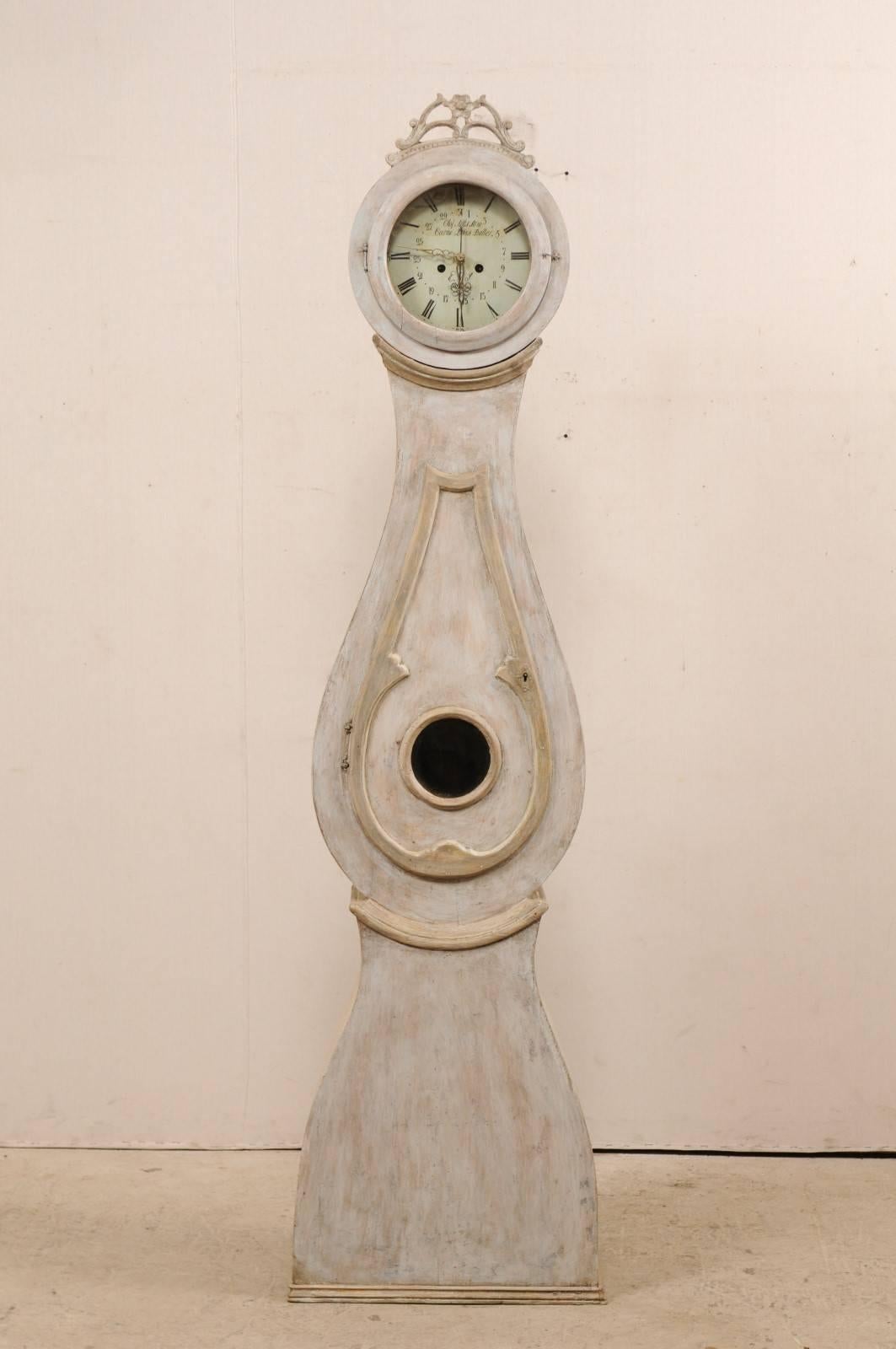 A Swedish 19th century Mora clock with beautifully pierced wood crown. This antique Mora clock features a sweetly carved pierced wood crest adorn with gently scrolling foliage with a flower at it's upper centre. The circular face, with Roman numeral