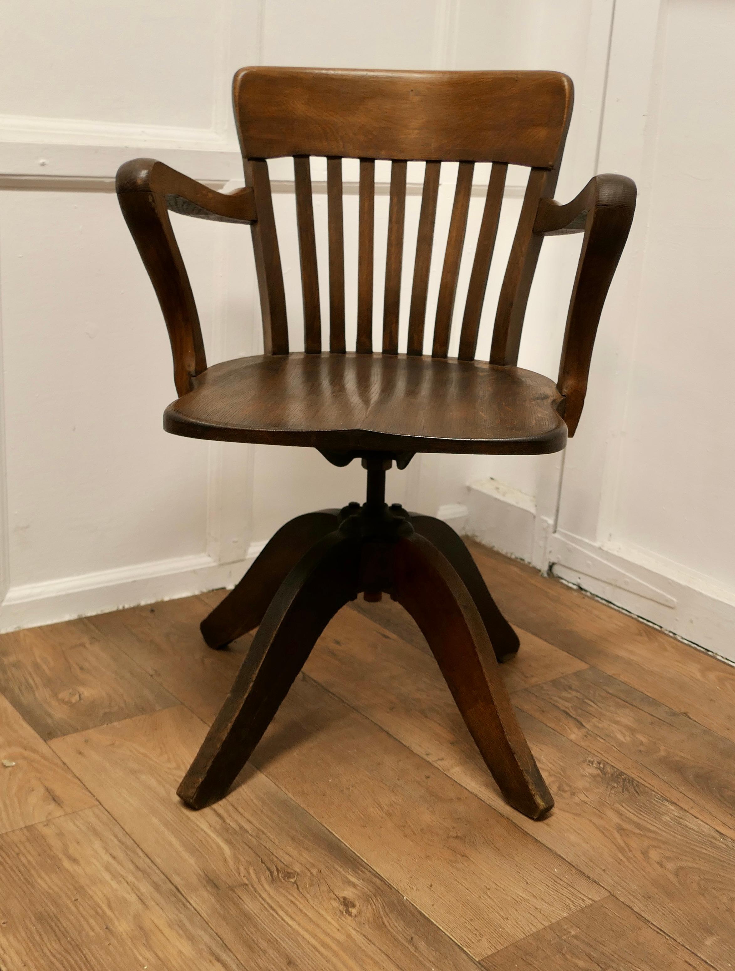 A 19th Century Swivelling Oak Office Chair or Desk Chair  

The Chair has an attractive deep curving back top rail with slats and arching Shepherds Crook Arm Rests. The Chair has a sculptured seat and revolves, also the height can be adjusted from
