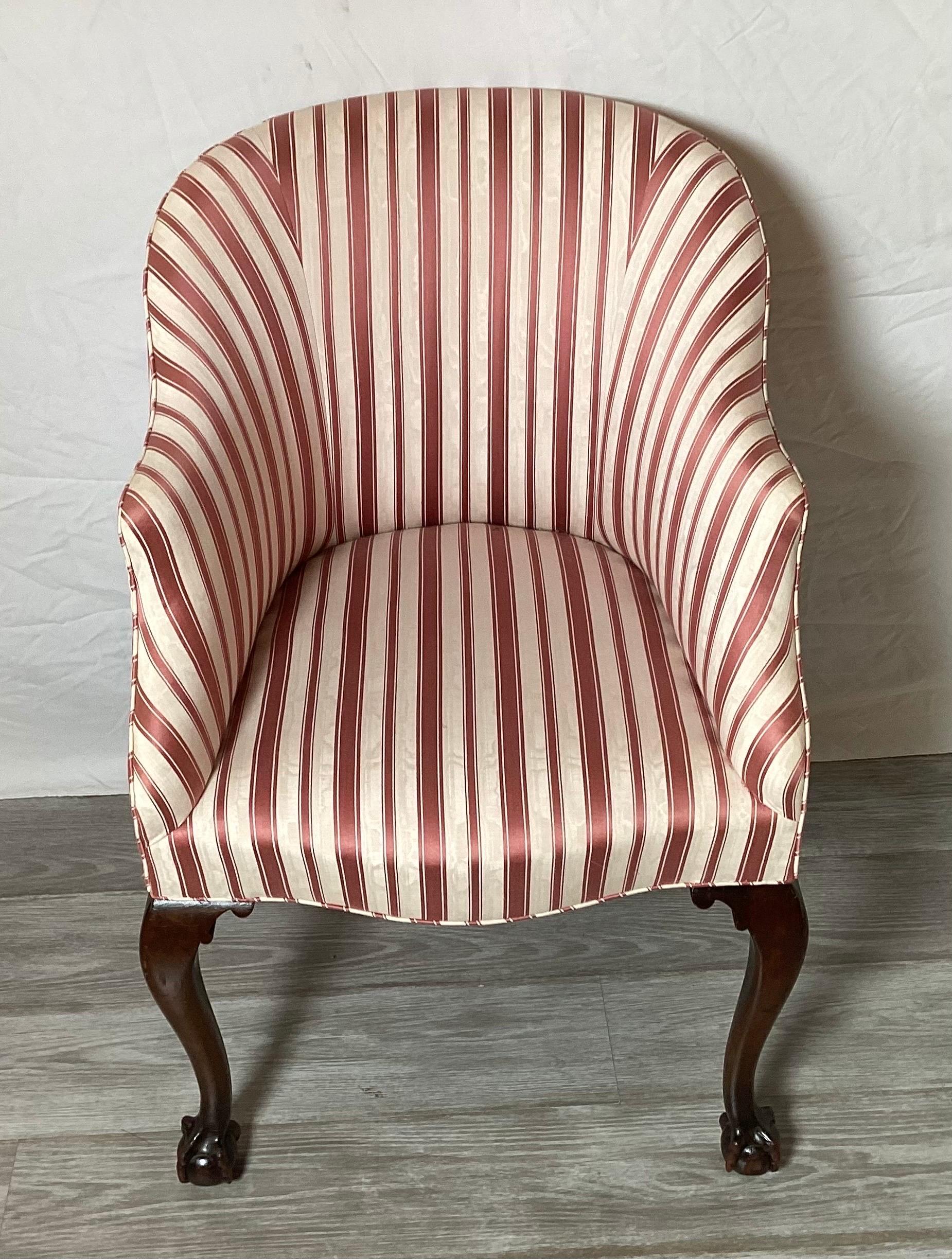 A Diminutive tub back Chippendale vanity accent chair. The dark mahogany legs with ball and claw feet with a rounded back recently upholstered in a red and cream moiré stripe fabric.