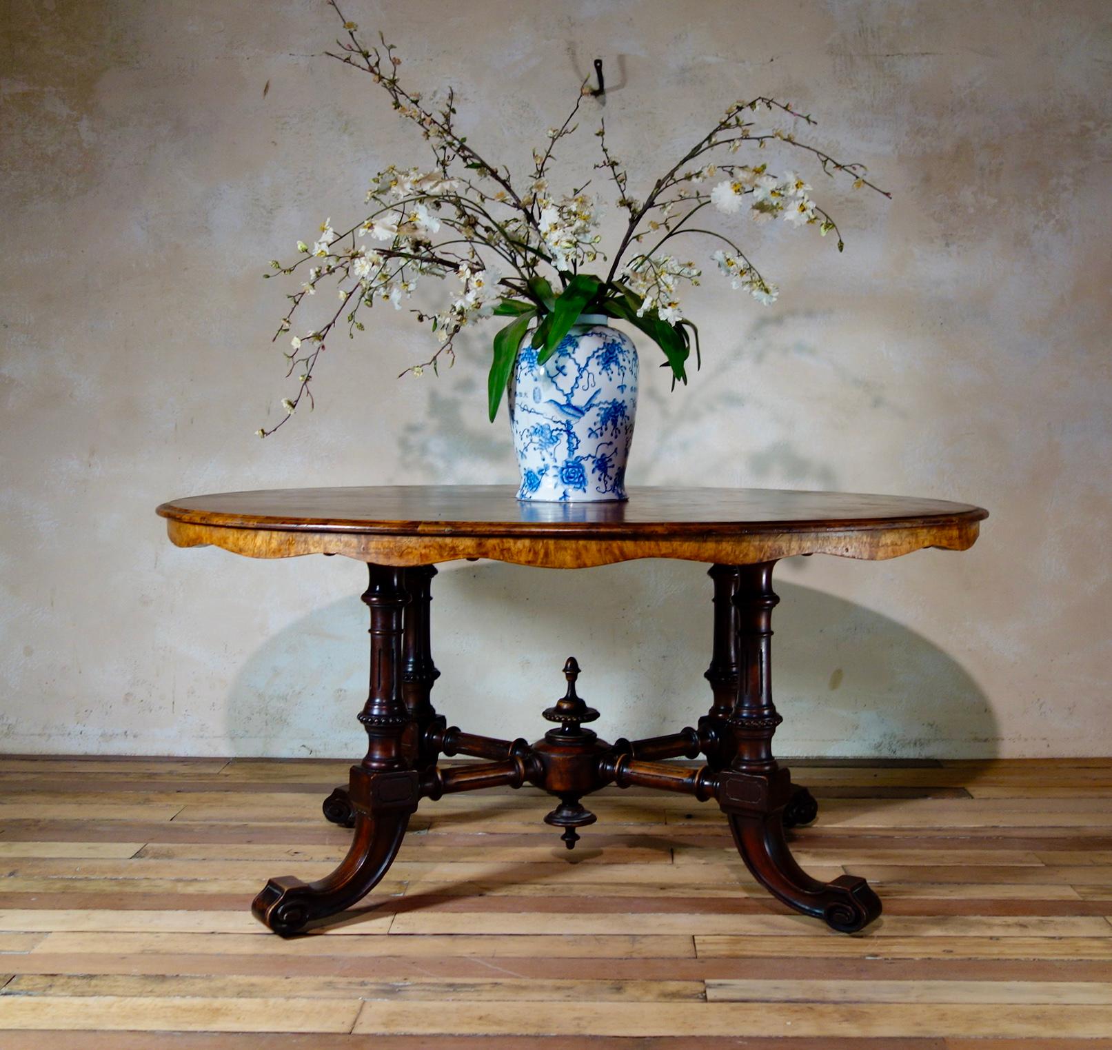 A Victorian oval burr walnut veneered breakfast table, featuring an intricately shaped four-leg base with delicately carved detailing throughout.  This table demonstrated a quarter veneered surface to the table top, with some repairs, adding a great
