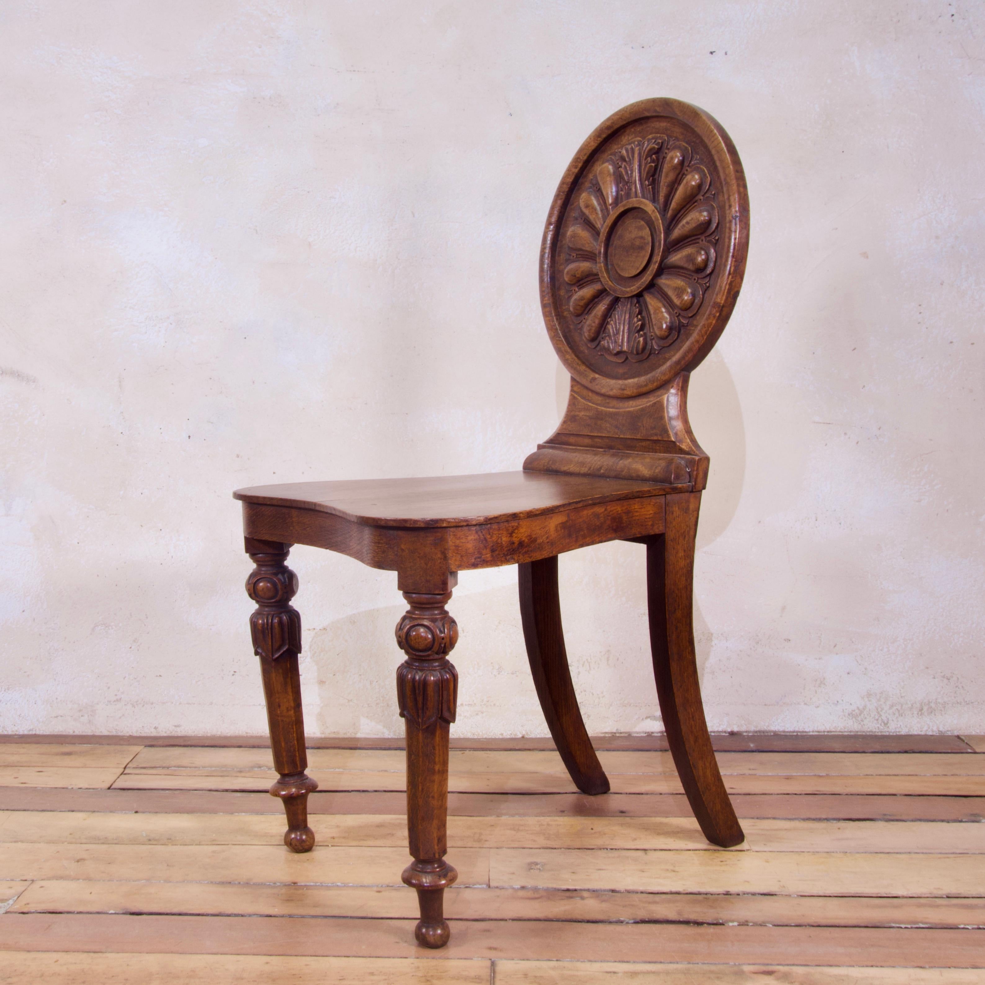 A charming 19th century William IV elm and burr elm hall chair, circa 1830. Displaying a lobed and carved circular back with central vacant roundel above the shaped seat and turned carved and faceted tapering legs. 


Dimensions:
Height 89cm