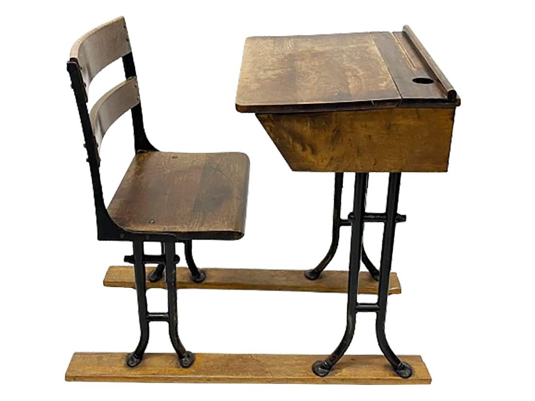A 19th Century wooden children's school desk

A wooden children's school desk with an iron base, mounted on 2 slats (sawn off). The lid of the desk has a pen rest (a slot in the wood) and a round opening on the right for a glass container, which is