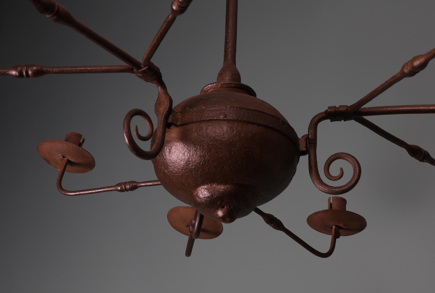 A 19th Century Wrought-Iron Chandelier. The central collared wrought bulb supports three triple-branched candle-holders. Waxed finish.
Wear consistent with age and use.