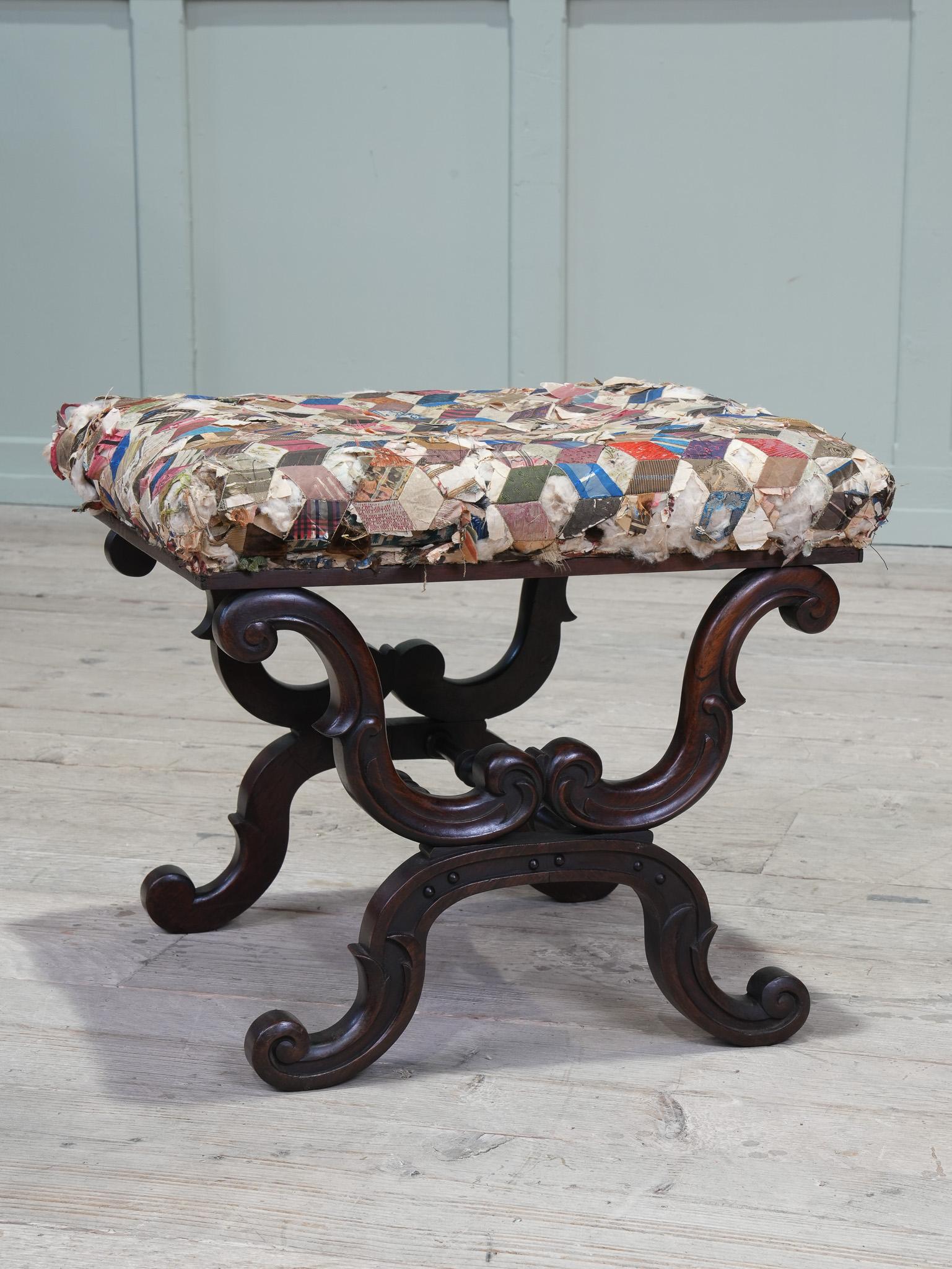 The seat upholstered in a worn tumbling block silk work tapestry, particularly well carved rosewood X-frame base.