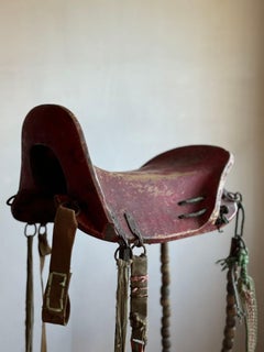 A 19thC Chinese carved and painted wooden saddle with tack.