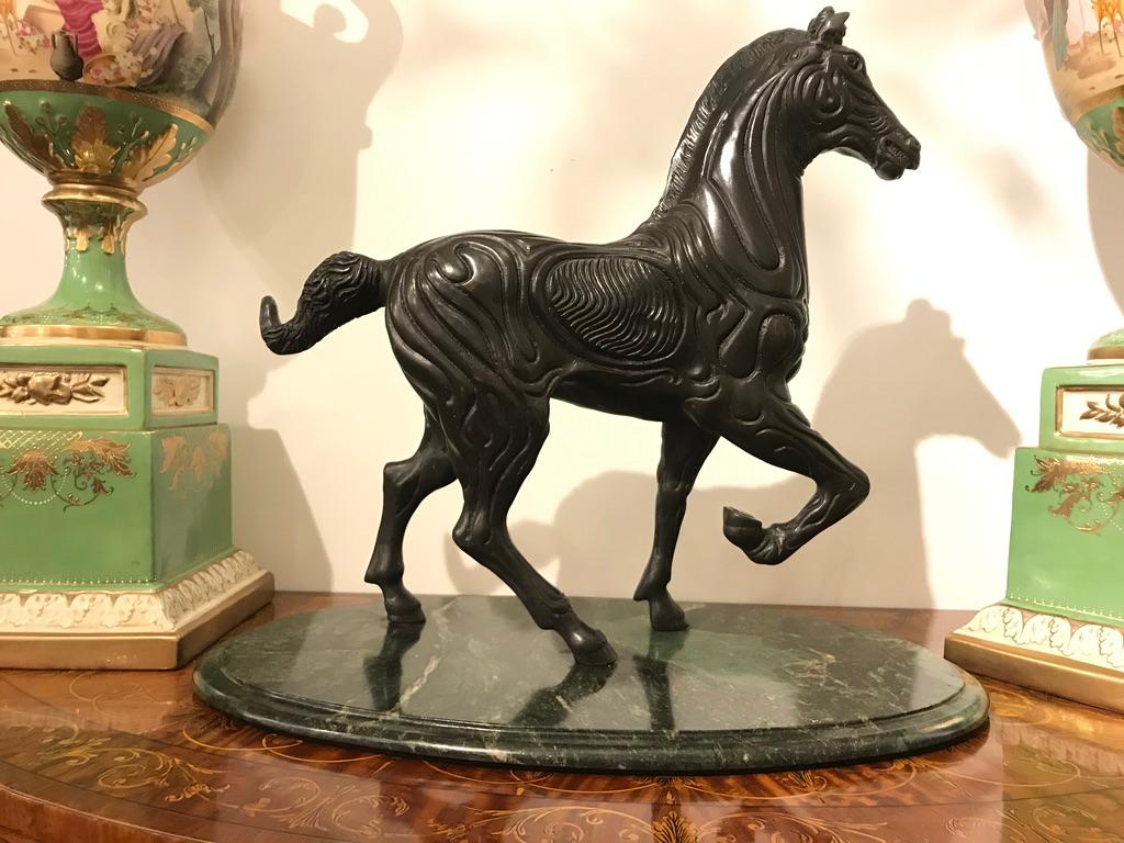 Un cheval décoratif en bronze avec de beaux détails et de la patine sur une belle base en marbre vert.