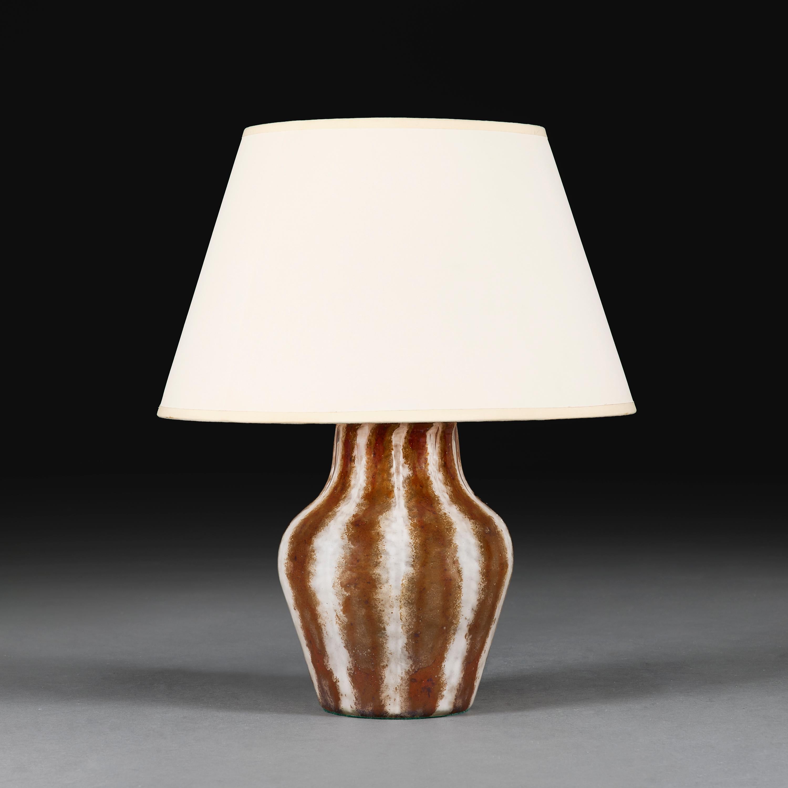 Italia, circa 1940.

Vaso in vetro di Murano a righe verticali bianche e marroni del XX secolo, ora montato come lampada.

Altezza 26,00 centimetri.
Diametro 19,00 centimetri.

Nota bene:

Paralume non incluso.  Lampada fotografata con un paralume