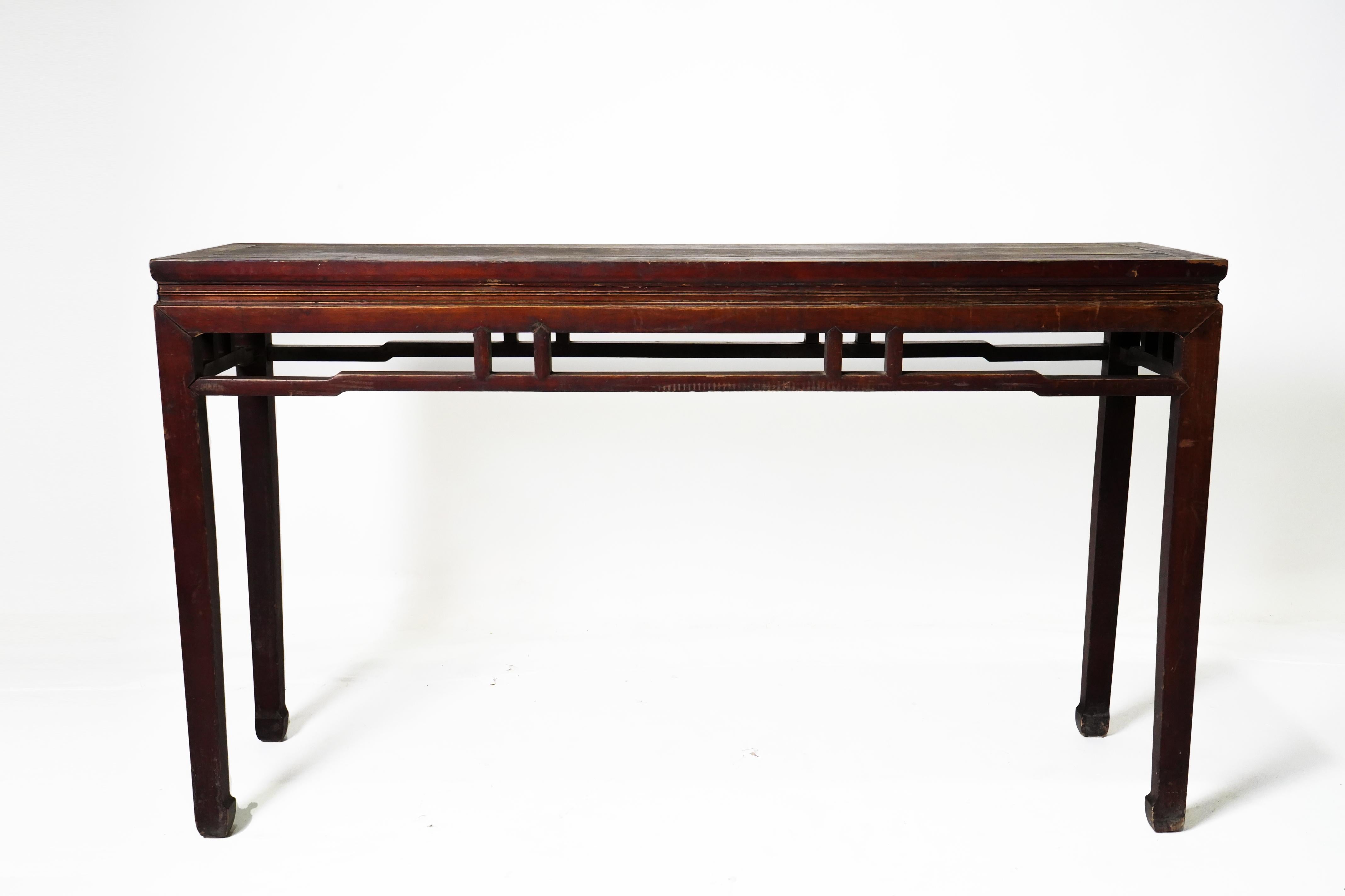 This slim and elegant table was once used to serve wine during festival days and to display objects of beauty and value. It has a floating panel top, a narrow waist and graceful Tang-inspired horse hoof-shaped legs. The bright red oxblood lacquer