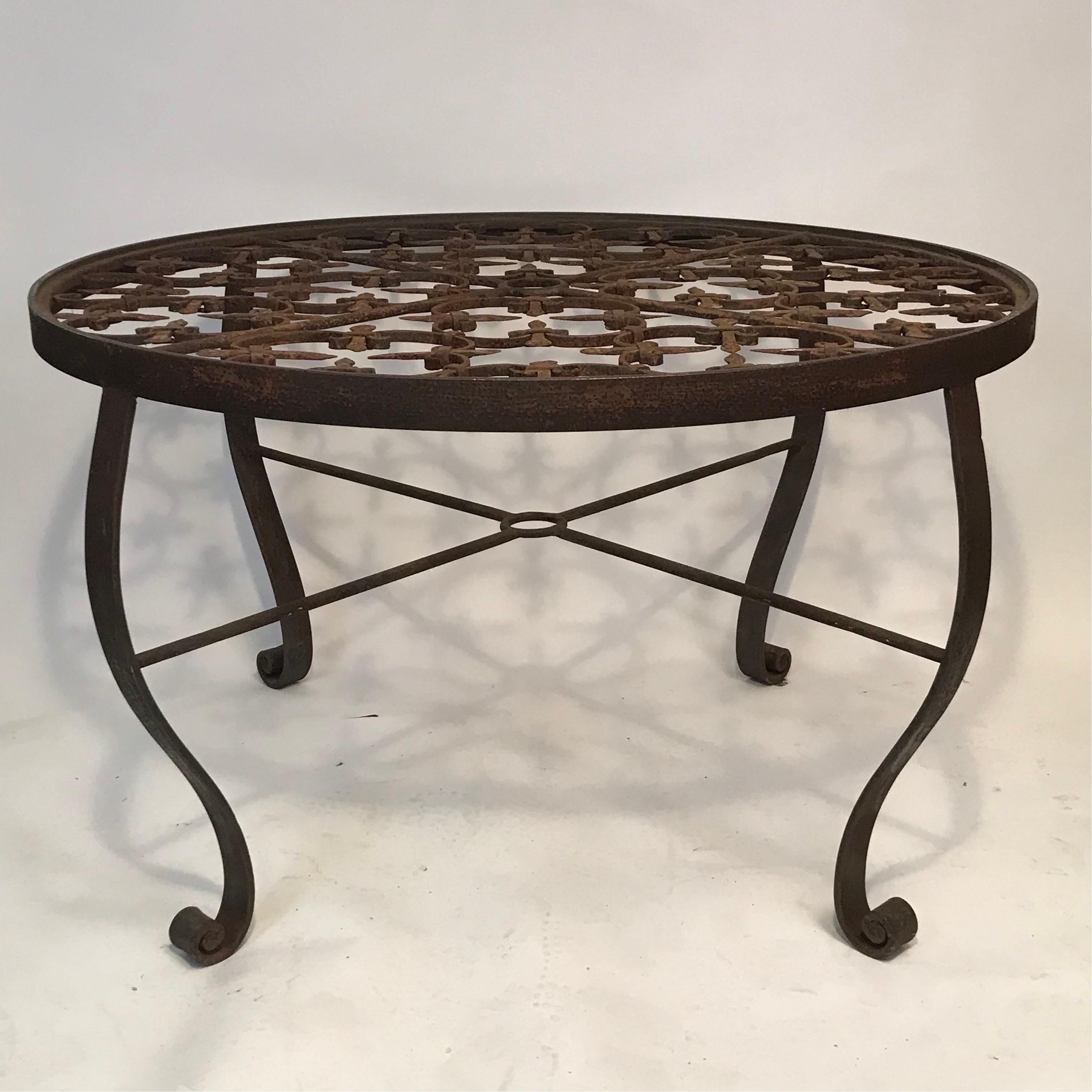 A contemporary outdoor garden table made from the architectural remnants of an early 20th  Century French outdoor gate set in an iron hoop frame recessed for a glass top set on euro antique styled curved legs in the same steel banding as the hoop,