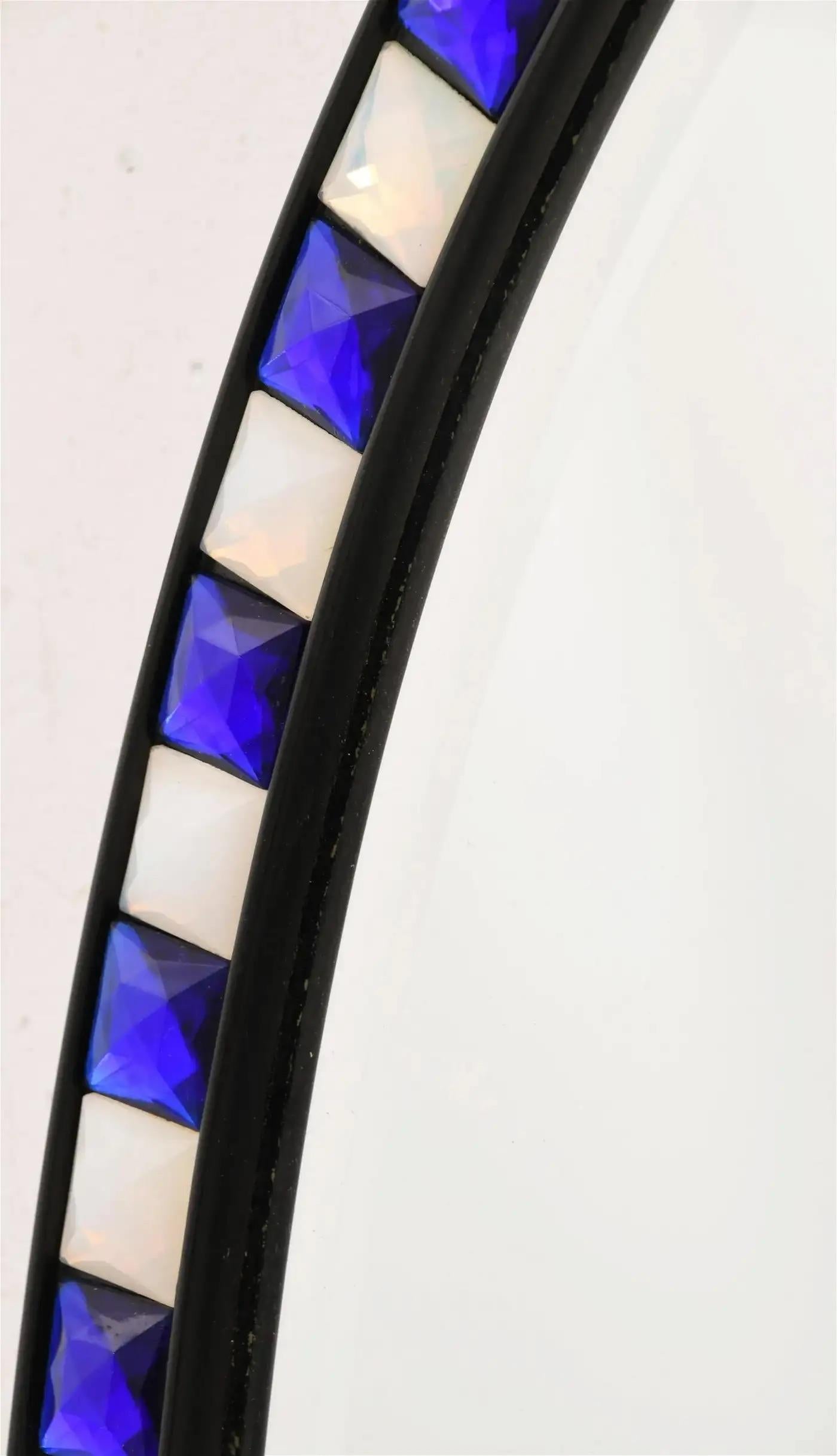 Espejo ovalado del siglo XX con paneles de cristal azul y blanco alternados en los bordes y dorados a la manera tradicional del siglo XVIII. Circa 1920s.