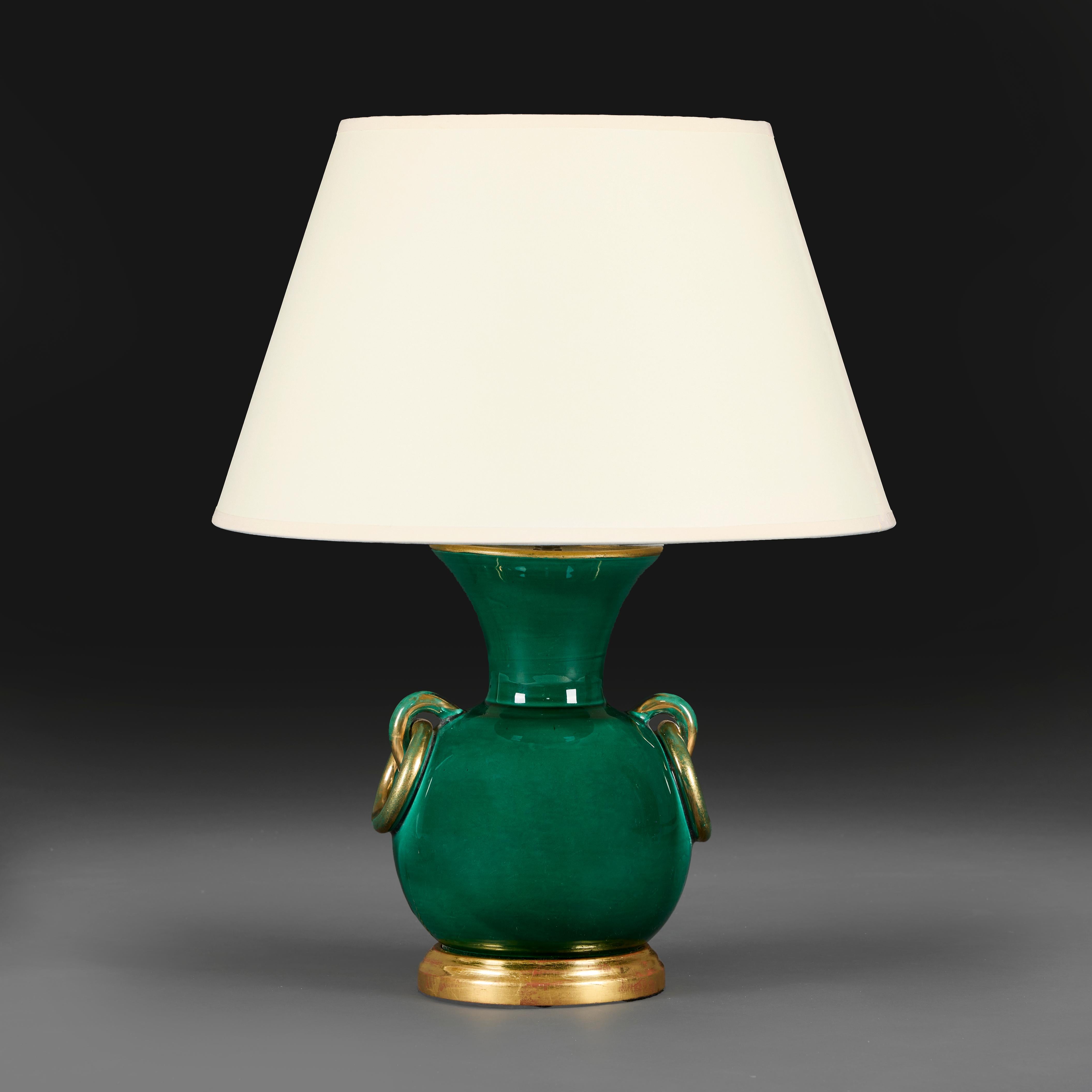 Italia, hacia 1930
Inusual jarrón de cerámica de los años 30 con esmalte verde y asas de lazo doradas, montado sobre una base de madera dorada.

Altura del jarrón             26.50cm
Altura con sombra      51.50cm
Diámetro del cuerpo      