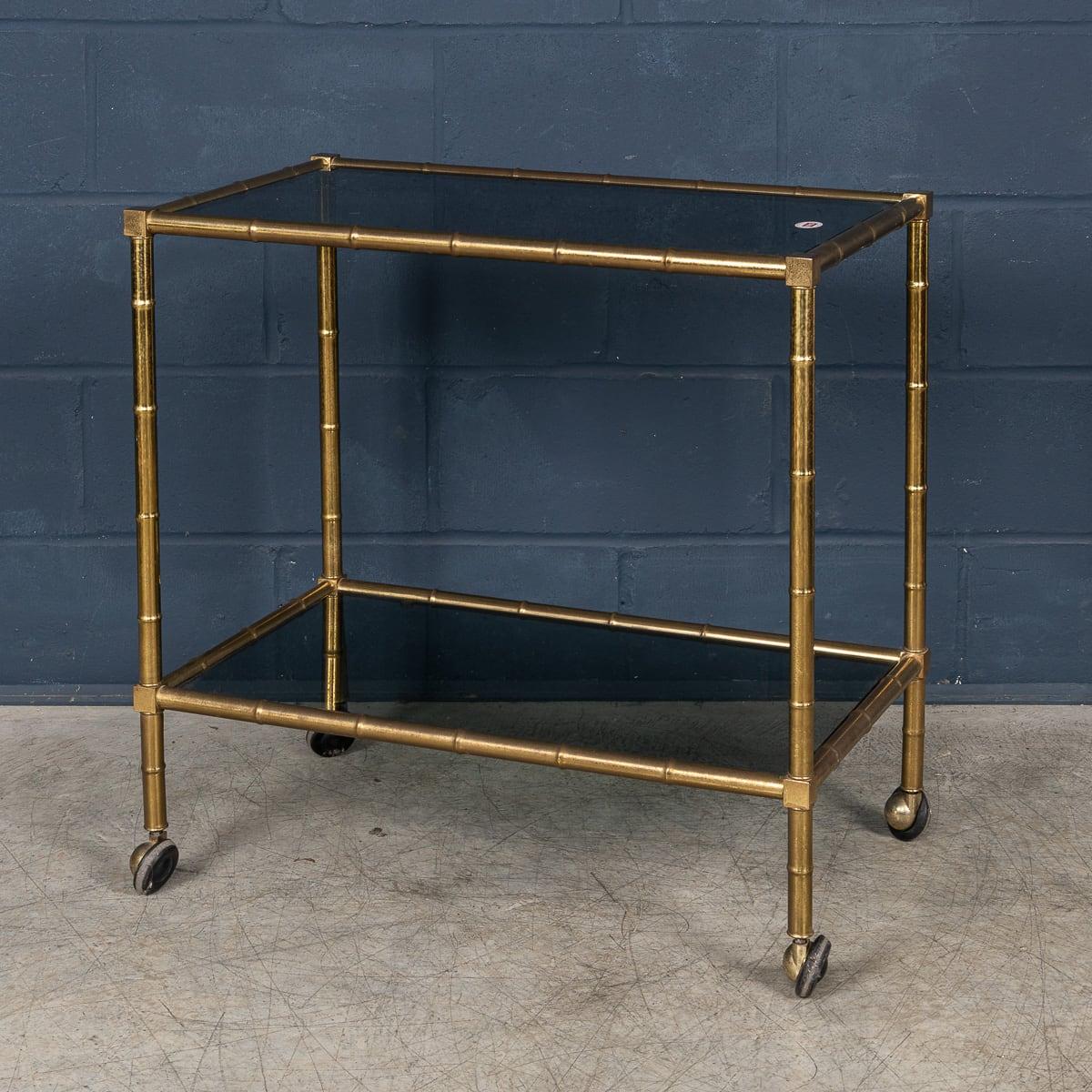 Carrello portabevande a due piani in ottone della metà o della fine del XX secolo, con una struttura circolare in ottone modellata con un effetto di finto bambù, tipico del design di quel periodo. Questo carrello portabevande o cocktail di design