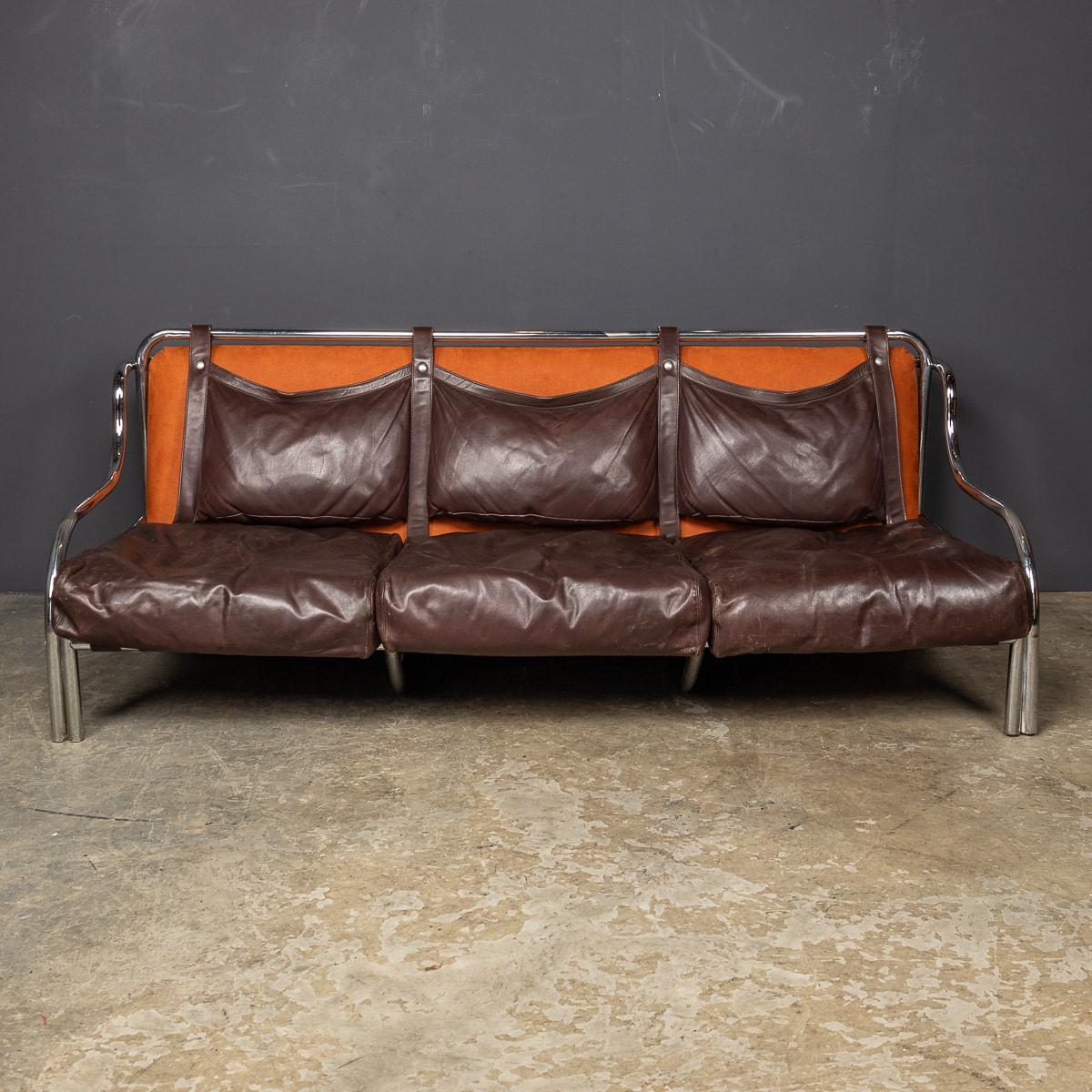 A superb Italian Brown leather sofa from the 20th century. Dubbed the “Stringa,” this masterpiece was crafted and conceived in Italy by Gae Aulenti for Poltronova in 1962. With its tubular chrome frame and luxurious leather cushioning, it stands as