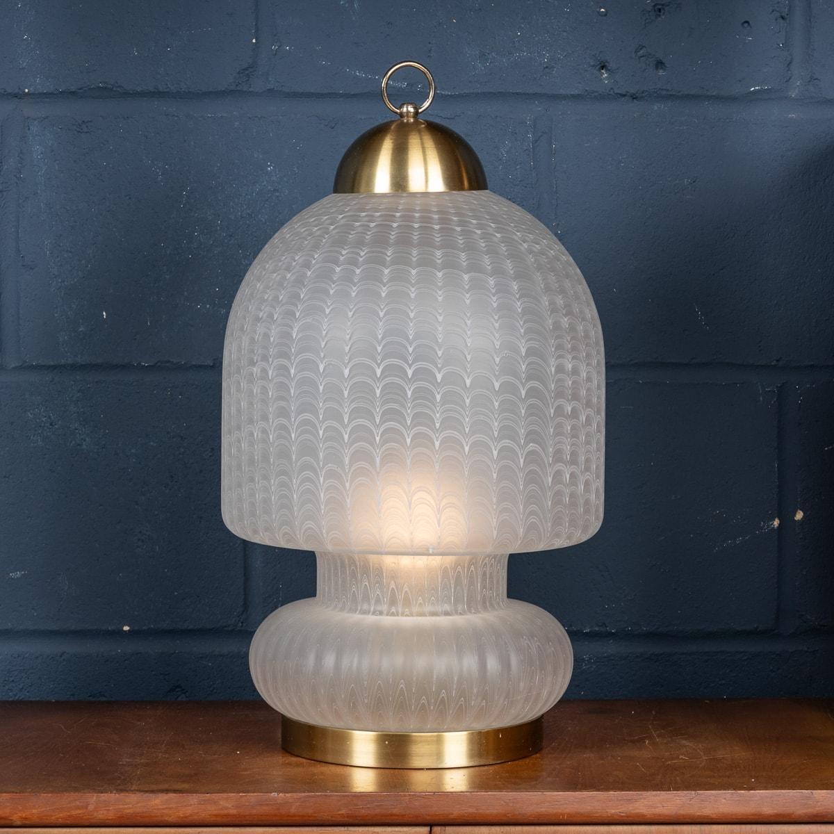 A stunning table lamp made in Murano, Venice towards the latter end of the 20th century. Encased within a lantern-like structure, the bulb is encased by a glass body which was hand blown by an extremely talented maestro. The technique used is called